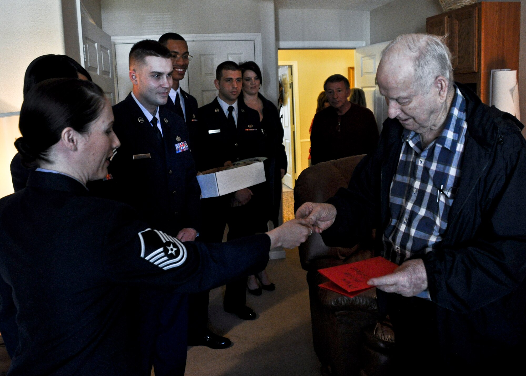 Master Sgt. Erika Follmar, 46th Test Wing, presents a lapel pin to Air Force veteran Grady Holmes Feb. 14, during her visit to Wellington Place in Fort Walton Beach, Fla.   Master Sgt. Follmar joined more than 200 Eglin Airmen who presented homemade valentines and flowers to local retirement home residents.  (U.S. Air Force photo/Kevin Gaddie)