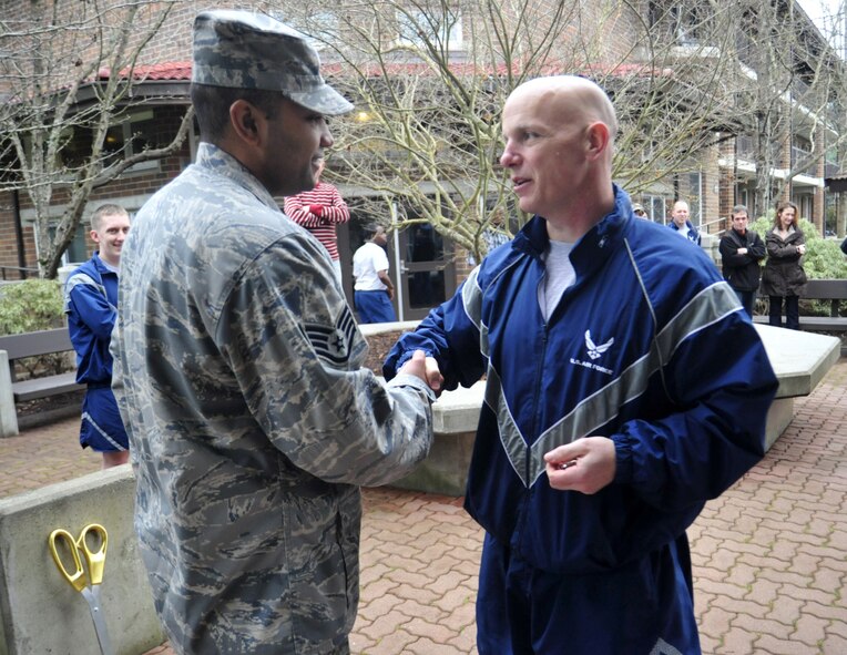 Staff Sgt. Nahkoma Doyle, left, 627th Civil Engineering Squadron dormitory manager, shakes hands with Chief Master Sgt. Gregory Warren, 62nd Airlift Wing command chief, after the opening of the Airmen Activities Center Feb. 11 at Joint Base Lewis-McChord, Wash. “It’s great to see a project come together like this and benefit the Airmen,” said Sergeant Doyle. (U.S. Air Force photo/Airman 1st Class Leah Young)