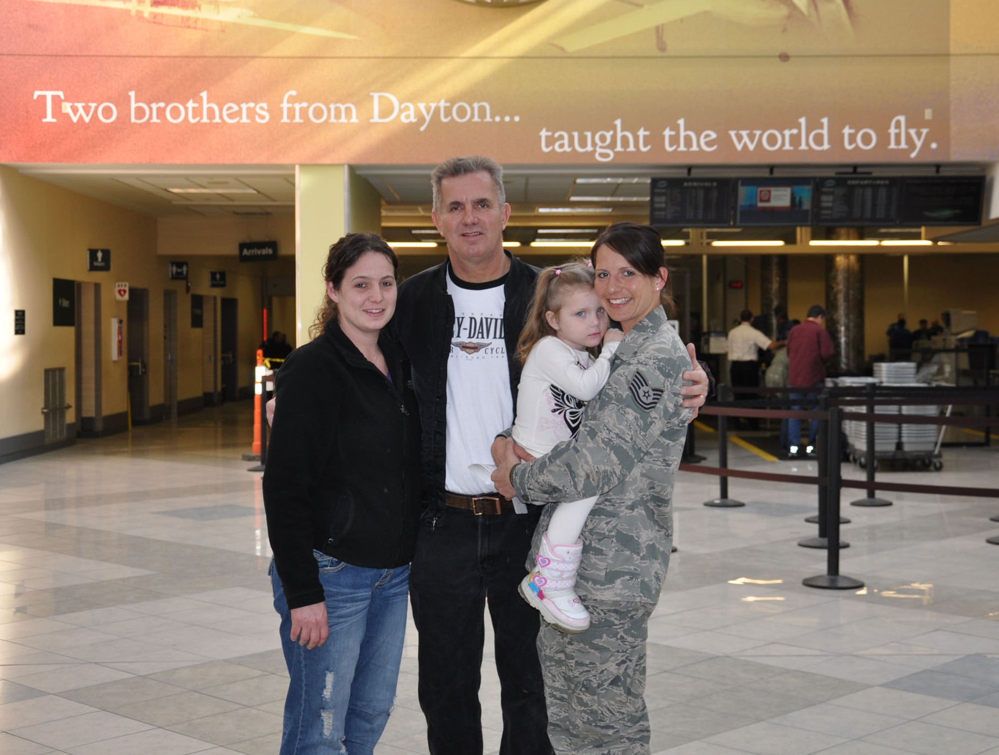 WRIGHT-PATTERSON AIR FORCE BASE, Ohio - Tech. Sgt. Leslie Lovegrove, 87th Aerial Port Squadron, receives a warm welcome home from her father, Dan Lough, and sister, Linsi Sparks, as she holds her niece, Hannah, at the Dayton International Airport Feb. 11 after returning home from a 4-month deployment to Joint Base Balad. (U.S. Air Force photo/Lt. Col. Cynthia Harris)
