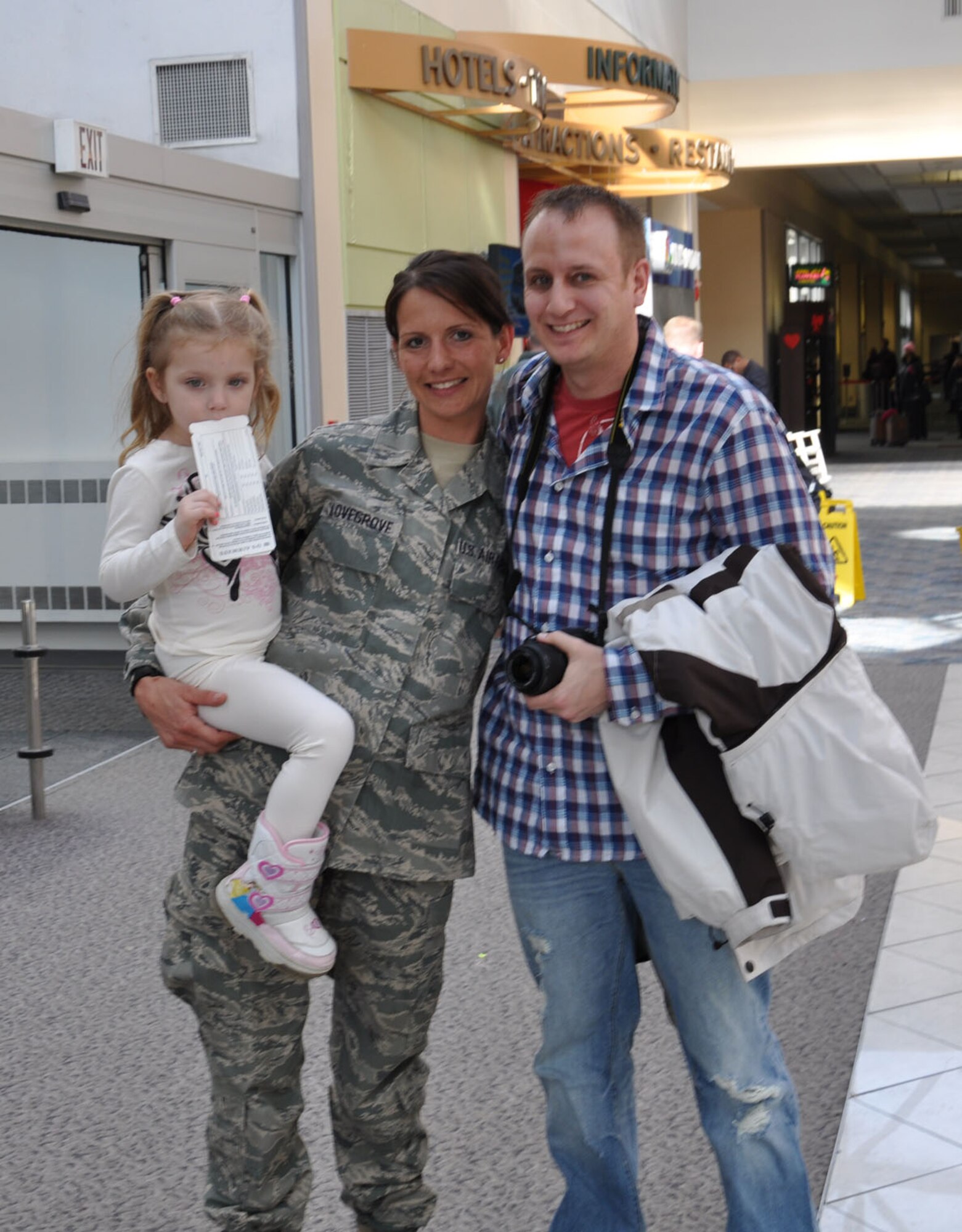 WRIGHT-PATTERSON AIR FORCE BASE, Ohio – Tech. Sgt. Leslie Lovegrove, 87th Aerial Port Squadron, receives a warm welcome home from her fiancé, Master Sgt. Scott Schrier, 445th Mission Support Group, while holding her niece, Hannah, at the Dayton International Airport Feb. 11 after returning home from a 4-month deployment to Joint Base Balad. (U.S. Air Force photo/Lt. Col. Cynthia Harris) 
