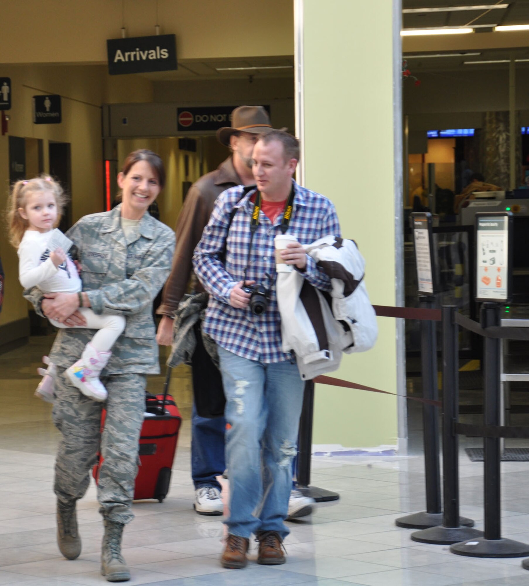 WRIGHT-PATTERSON AIR FORCE BASE, Ohio – Tech. Sgt. Leslie Lovegrove, 87th Aerial Port Squadron, receives a warm welcome home from her fiancé, Master Sgt. Scott Schrier, 445th Mission Support Group, while holding her niece, Hannah, at the Dayton International Airport Feb. 11 after returning home from a 4-month deployment to Joint Base Balad. (U.S. Air Force photo/Lt. Col. Cynthia Harris) 
