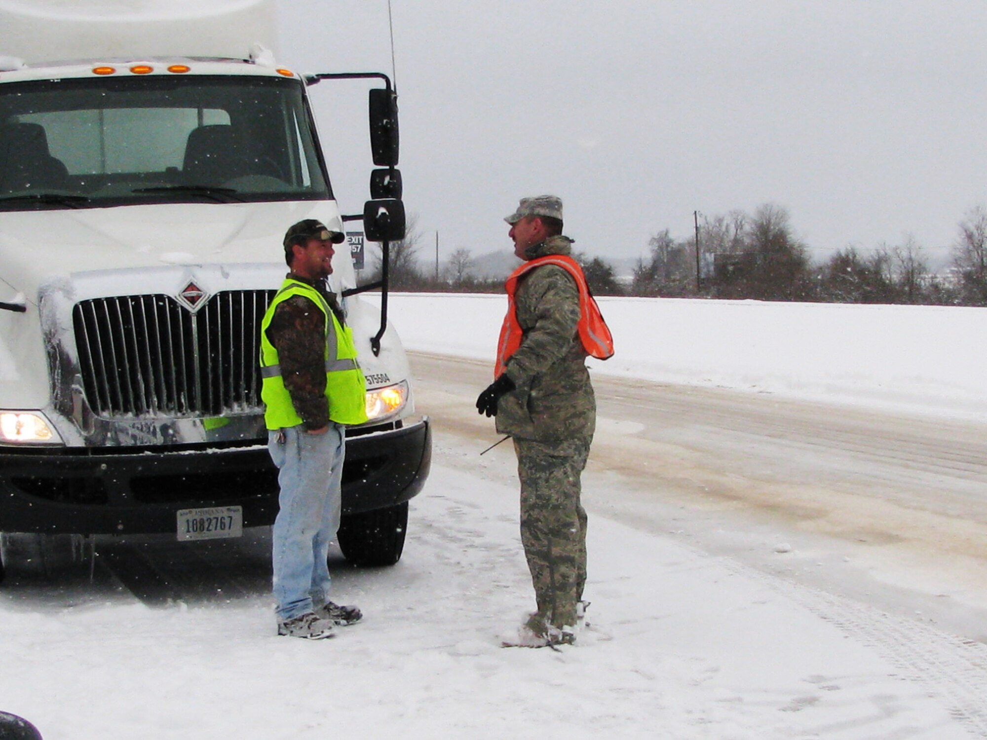 Tech. Sgt. James Crawford (right), a 189th Logistics Readiness Squadron Rapid Augmentation Team member, discusses details of an accident with a civilian truck driver on Highway I-40 Feb. 9, 2011, at Little Rock, Ark. The 189th Airlift Wing team's primary mission is to provide emergency response and assistance as directed by the governor of Arkansas. (U.S. Air Force photo by Tech. Sgt. Michael Caffey)