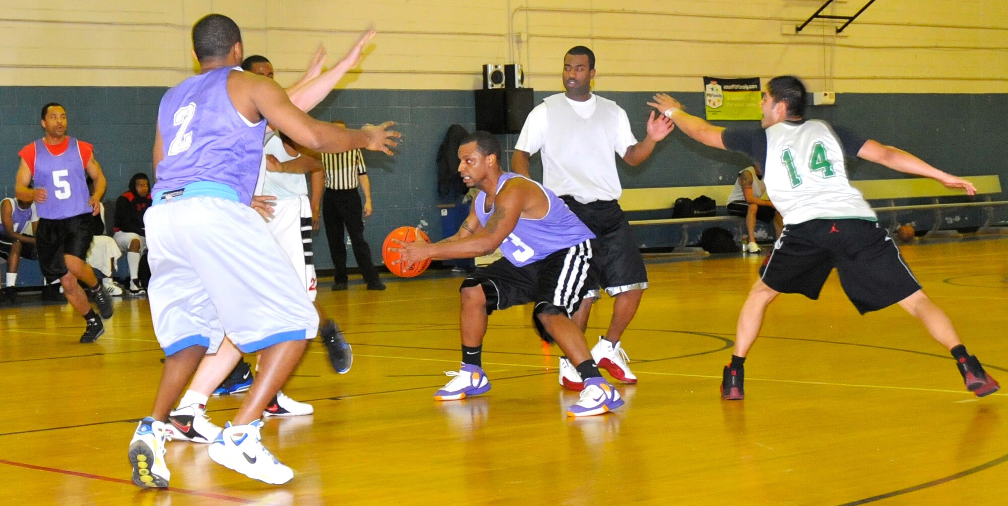 Senior Airman Jerome Jenkins, 512th Memorial Affairs Squadron, prepares to bass the ball to one of his 512th Force Support Squadron teammates during an intramural game against the 436th Aircraft Maintenance Squadron Feb. 10 at the fitness center. The 512th FSS team won the game 42-36, which brings their record to 10-3. The Reserve basketball team is currently tied for first place in the national division; they've won two of the past three base basketball championships. (Air Force photo by Staff Sgt. Danella Shea/Released)