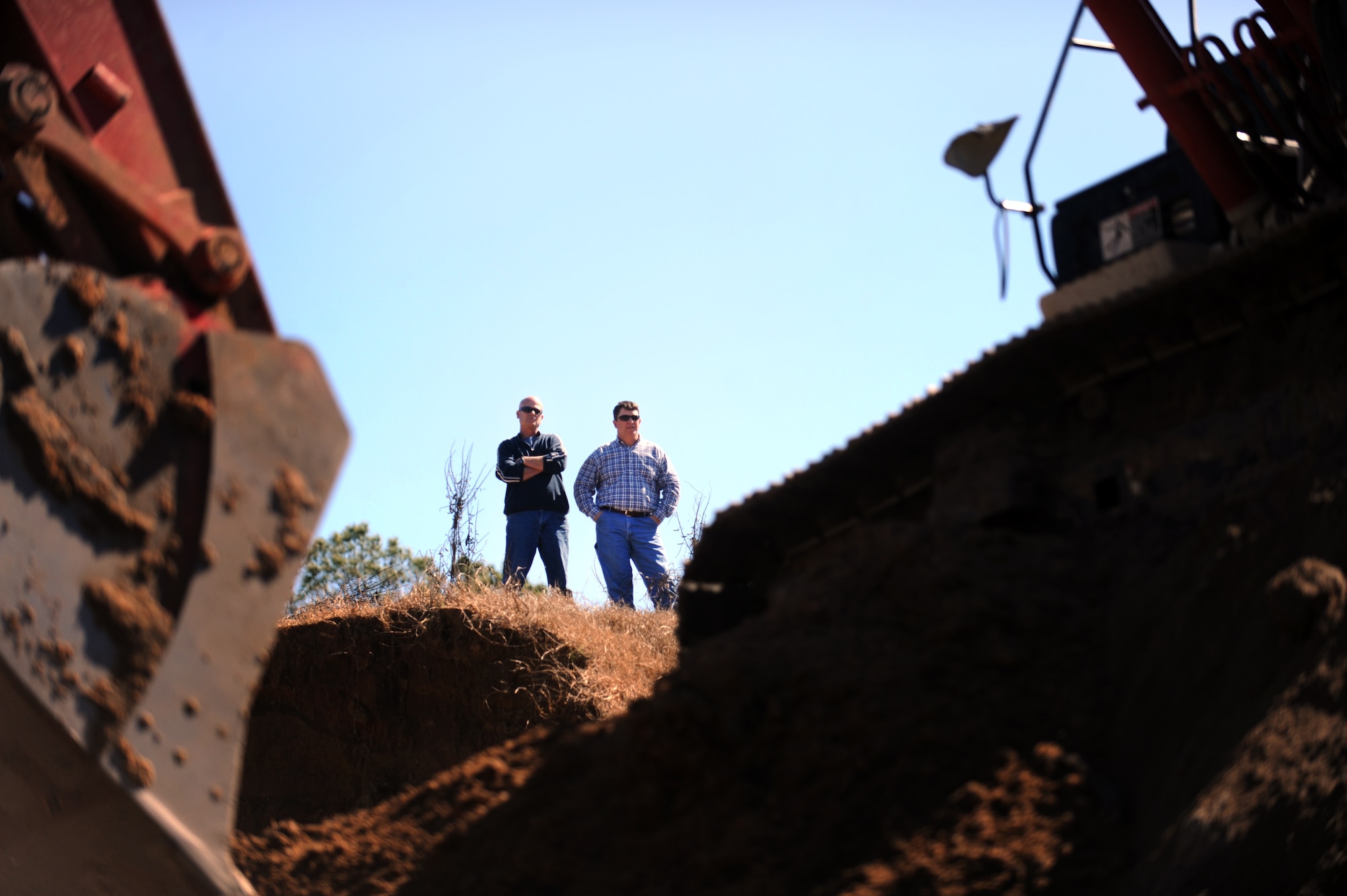 MOODY AIR FORCE BASE, Ga. -- Gary Lamb, 23rd Civil Engineer Squadron heavy equipment shop work leader, and Morgan Spruill, 23rd CES deputy chief of operations, watch other members from the 23rd CES build a berm at the Combat Arms Training and Maintenance range Feb. 14. This berm will be used to keep bullets from traveling past the range and possibly prevent someone from getting injured. (U.S. Air Force photo/Airman 1st Class Douglas Ellis)(RELEASED)
