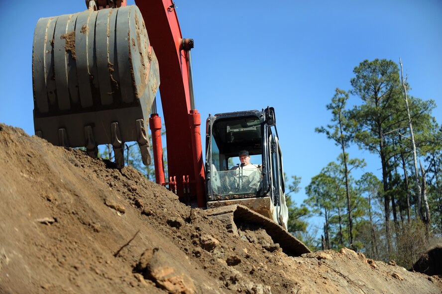 MOODY AIR FORCE BASE, Ga. -- Staff Sgt. Danny Kelton, 23rd Civil Engineer Squadron pavement and equipment craftsman, adds dirt to a berm using an excavator Feb. 14. Upon completion, the new Combat Arms Training and Maintenance range will have two facilities to utilize during training. (U.S. Air Force photo/Airman 1st Class Douglas Ellis)(RELEASED)
