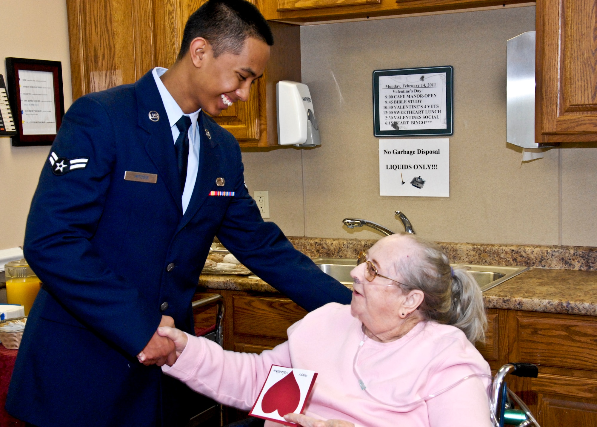 Airman 1st Class Norman Hitosis, 96th Force Support Squadron, visits with Jean Kidd during a Feb. 14 visit to 'The Manor' at Blue Water Bay in Niceville, Fla. The 82-year-old former civil servant at Eglin said she appreciated the gifts. Airman Hitosis joined more than 200 Eglin Airmen who presented homemade valentines to local retirement home residents. (U.S. Air Force photo/Sachel Seabrook)