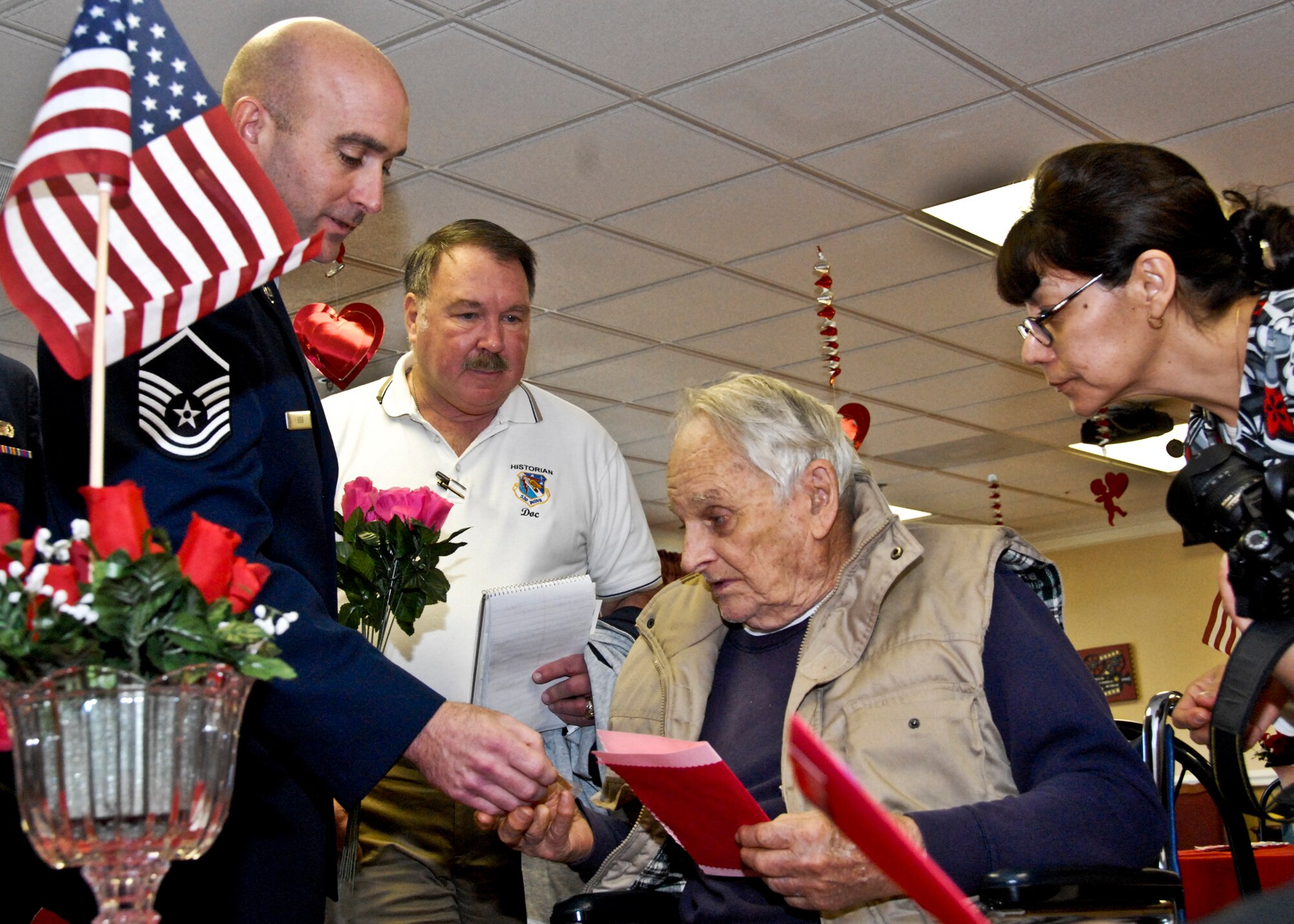 Master Sgt. Michael Bibb,  366th Training Squadron, gives Army veteran Edward Miller a lapel pin during a Feb. 14 visit to The Manor at Blue Water Bay in Niceville, Fla. He joined more than 200 Eglin Airmen who presented homemade valentines to local retirement home residents. Airmen also distributed flowers to veterans. (U.S. Air Force photo/Sachel Seabrook)