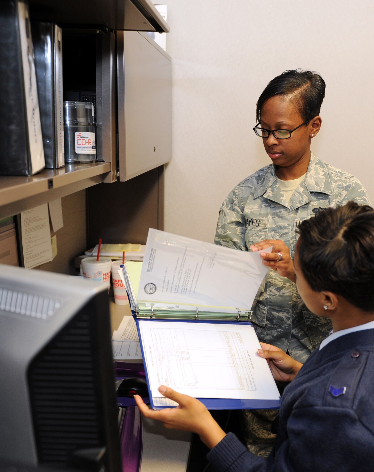 Staff Sgt. Natasha Hayes, a 19th Operations Group knowledge operations manager, reviews troubleshoot tickets with an Airman Feb. 14, 2011, at Little Rock Air Force Base, Ark. Sergeant Hayes submits approximately 30 trouble tickets to the 19th Communications Squadron weekly. (Air Force photo by Airman 1st Class Ellora Stewart)