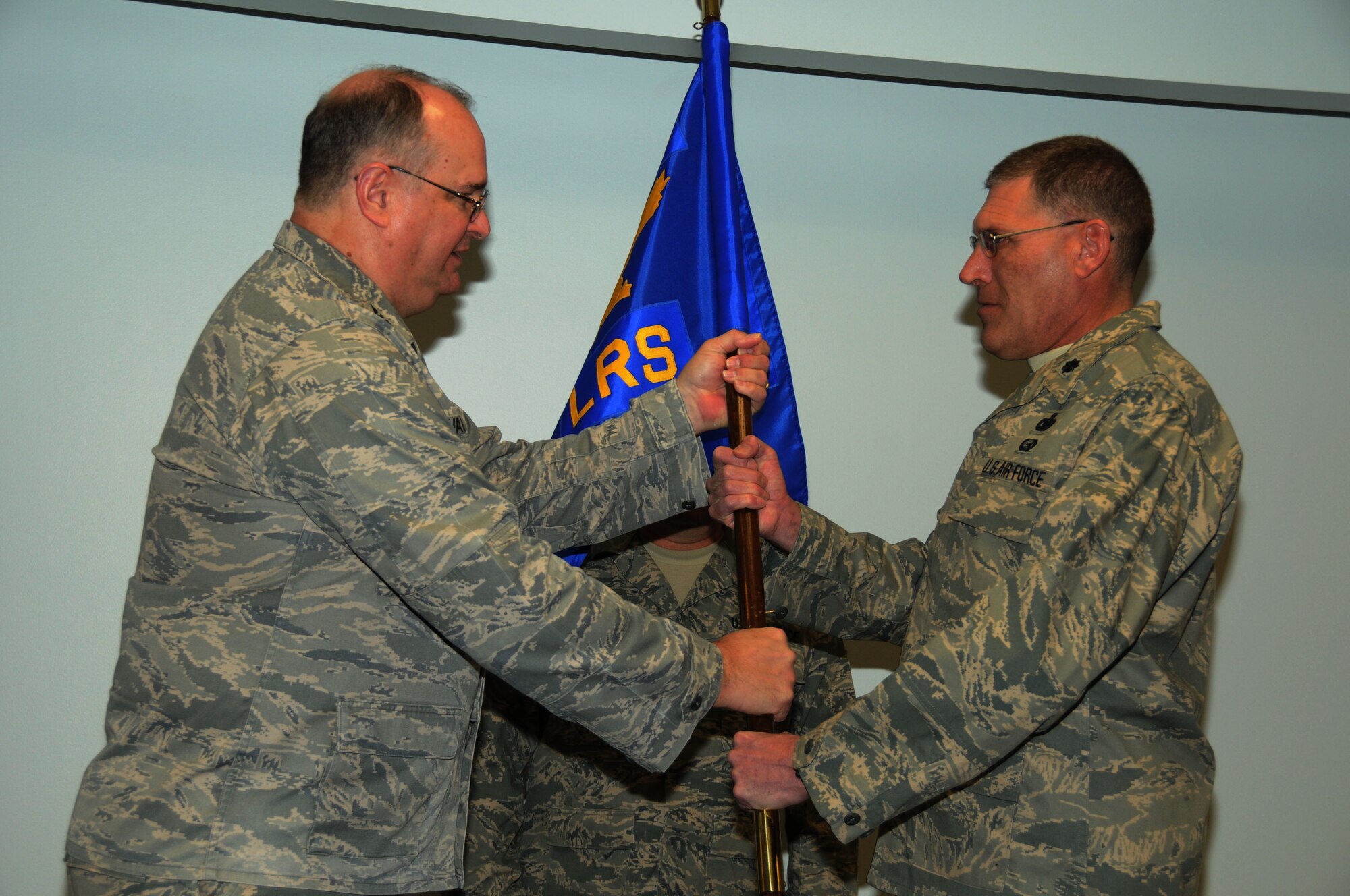 Lt. Col. Kenneth Anderson (on right) took command of the 107th Airlift Wing's Logistics Readiness squadron in a ceremony held here on Feb. 13. The colonel previously held the position as LRS operations officer and replaces outgoing LRS Commander Lt. Col. Steven Hefferon, who now holds the position of 107th Comptroller Flight Commander. Passing the LRS guidon is 107th Mission Support Group Commander Col. Timothy Vaughan. (U.S. Air Force photo/Tech. Sgt. Justin Huett)