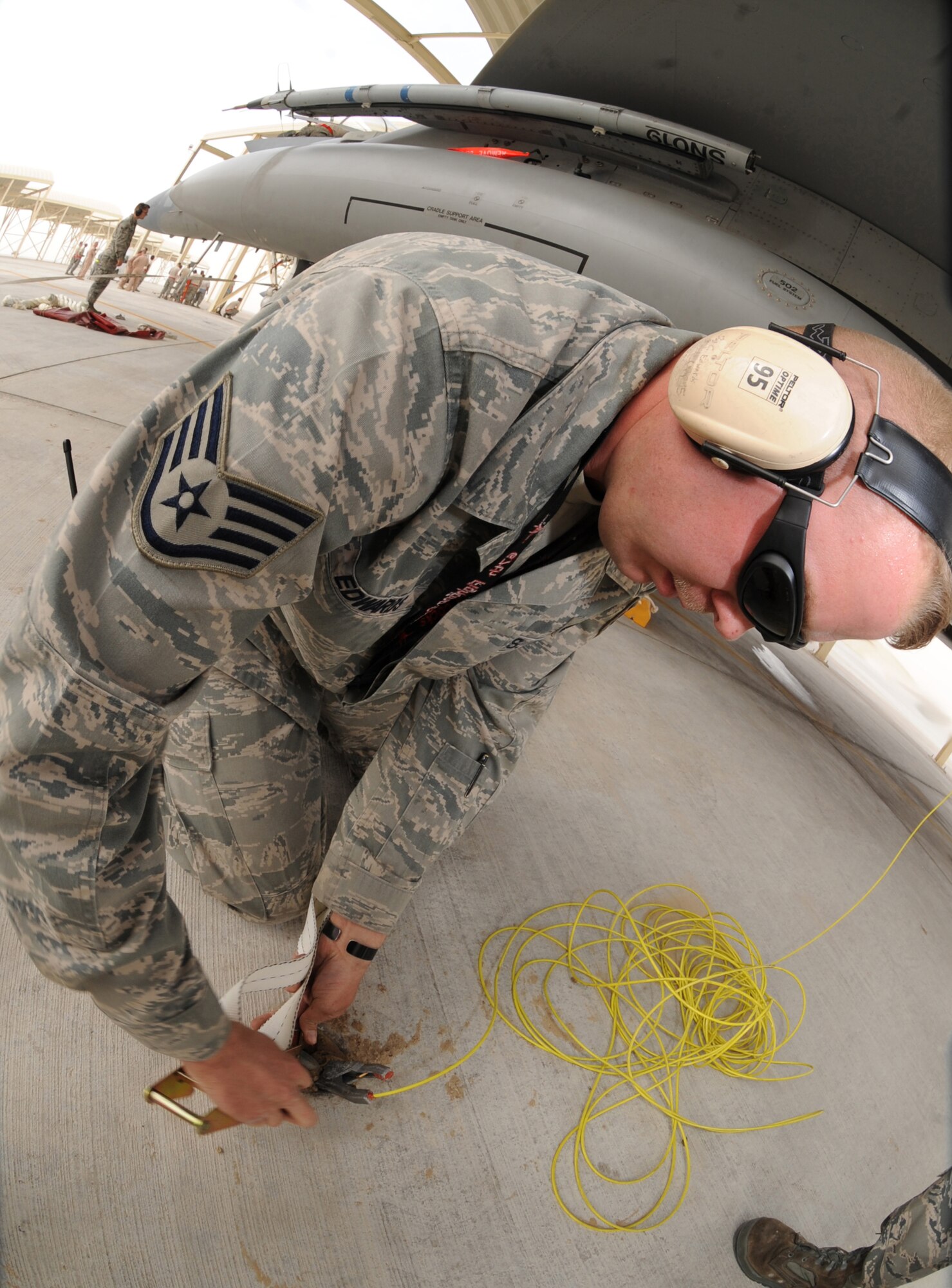 Staff Sgt. Christopher Edwards, 380th Expeditionary Maintenance Group, ties down an F-15C Eagle during high winds recently in Southwest Asia. The 67th Expeditionary Fighter Squadron currently flies the F-15C Eagle and is deployed from Kadena AFB, Japan. (U.S. Air Force photo by Senior Airman Maynelinne De La Cruz)