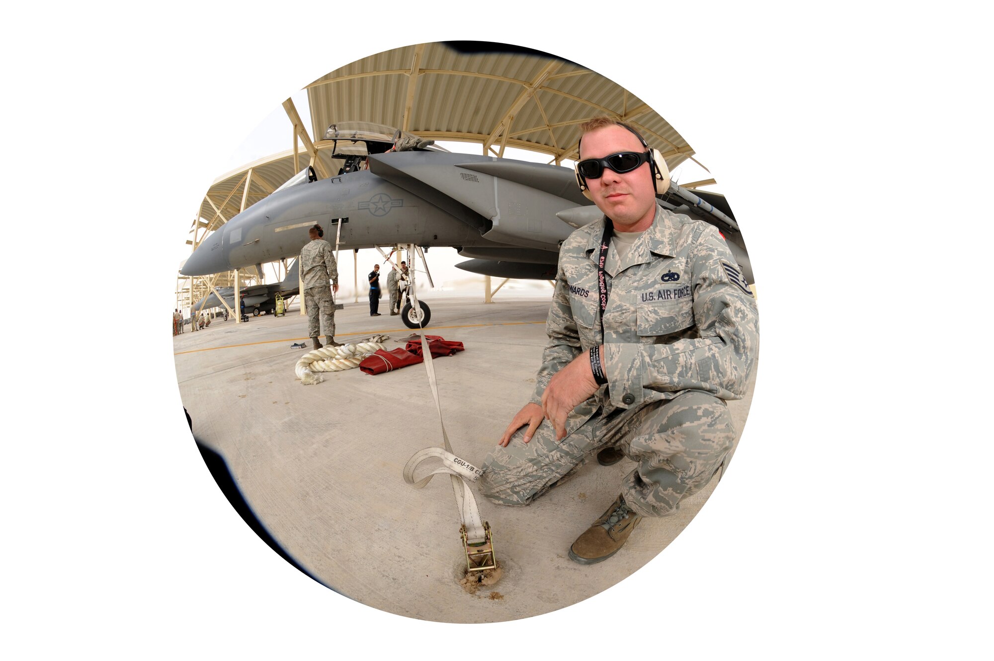 Staff Sgt. Christopher Edwards, 380th Expeditionary Maintenance Group, ties down an F-15C Eagle during high winds recently in Southwest Asia. The 67th Expeditionary Fighter Squadron currently flies the F-15C Eagle and is deployed from Kadena AFB, Japan. (U.S. Air Force photo illustration by Senior Airman Maynelinne De La Cruz)