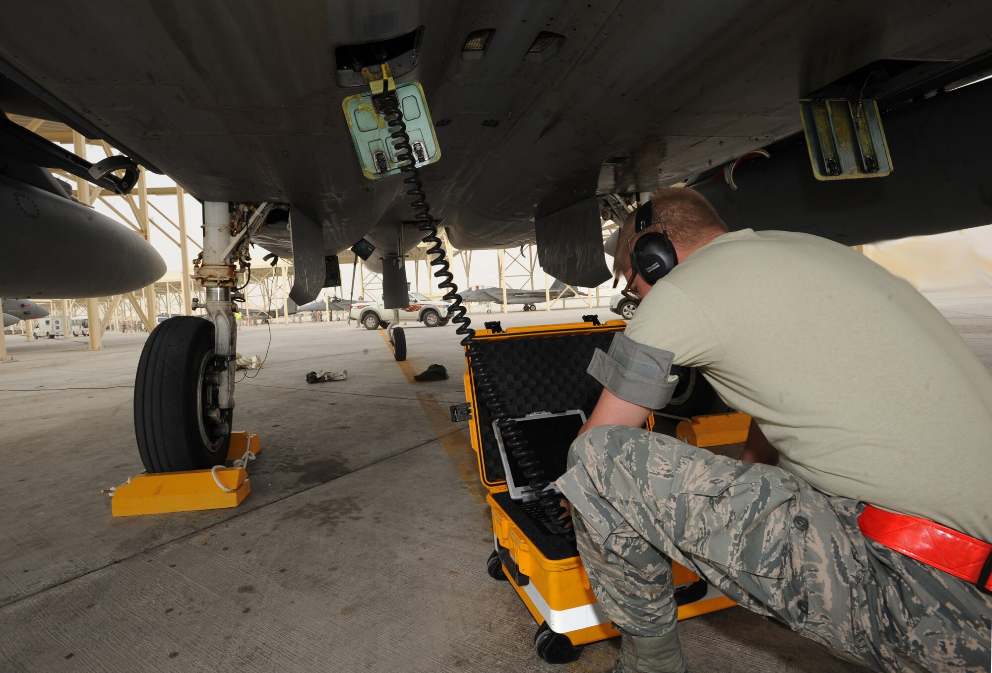 Airman 1st Class Daren Farber, 380th Expeditionary Aircraft Maintenance Squadron, performs the maintenance post-flight data down on an F-15C Eagle recently in Southwest Asia. The 67th Expeditionary Fighter Squadron currently flies the F-15C Eagle and is deployed from Kadena AFB, Japan. (U.S. Air Force photo illustration by Senior Airman Maynelinne De La Cruz)