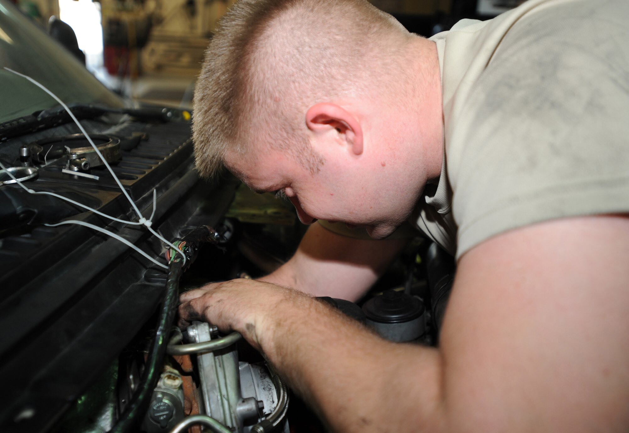 Airman 1st Class William Smith, 380th Expeditionary Logistics Readiness Squadron, conducts repairs on a truck at the vehicle maintenance shop. The shop generally services around three to five vehicles each day.  Airman Smith is deployed here from the 92nd LRS, Fairchild Air Force Base, Washington. (U.S. Air Force photo by Senior Airman Maynelinne De La Cruz)