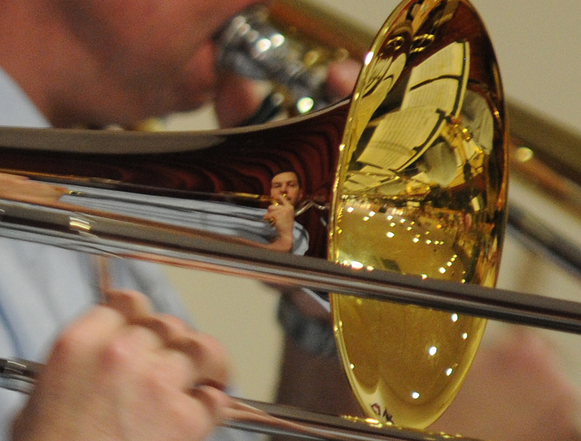 RAF MILDENHALL, England -- The face of Master Sgt. Charles Anderson, trombone player, reflects from his instrument as performs a solo in the song "Chega de Saudade" with the U.S. Air Forces in Europe Band Check Six ensemble at the Mildenhall Social Club Feb. 13, 2011. Sergeant Anderson performed at a free concert to local residents as a way to build partnerships and community relations. Attendance in the event was so high that the social club was nearly filled to capacity. (U.S. Air Force photo/Staff Sgt. Thomas Trower)