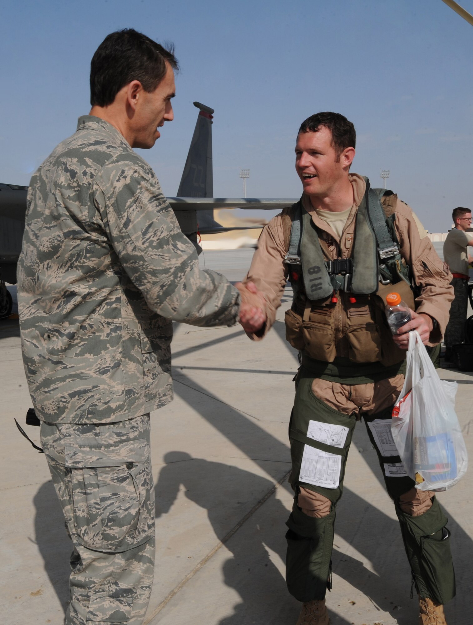 Brig. Gen. Mike Minahan, 380th Air Expeditionary Wing commander, greets a 67th Expeditionary Fighter Squadron pilot after arriving in Southwest Asia recently. The 67th EFS currently flies the F-15C Eagle and is deployed from Kadena AFB, Japan. (U.S. Air Force photo by Senior Airman Maynelinne De La Cruz)