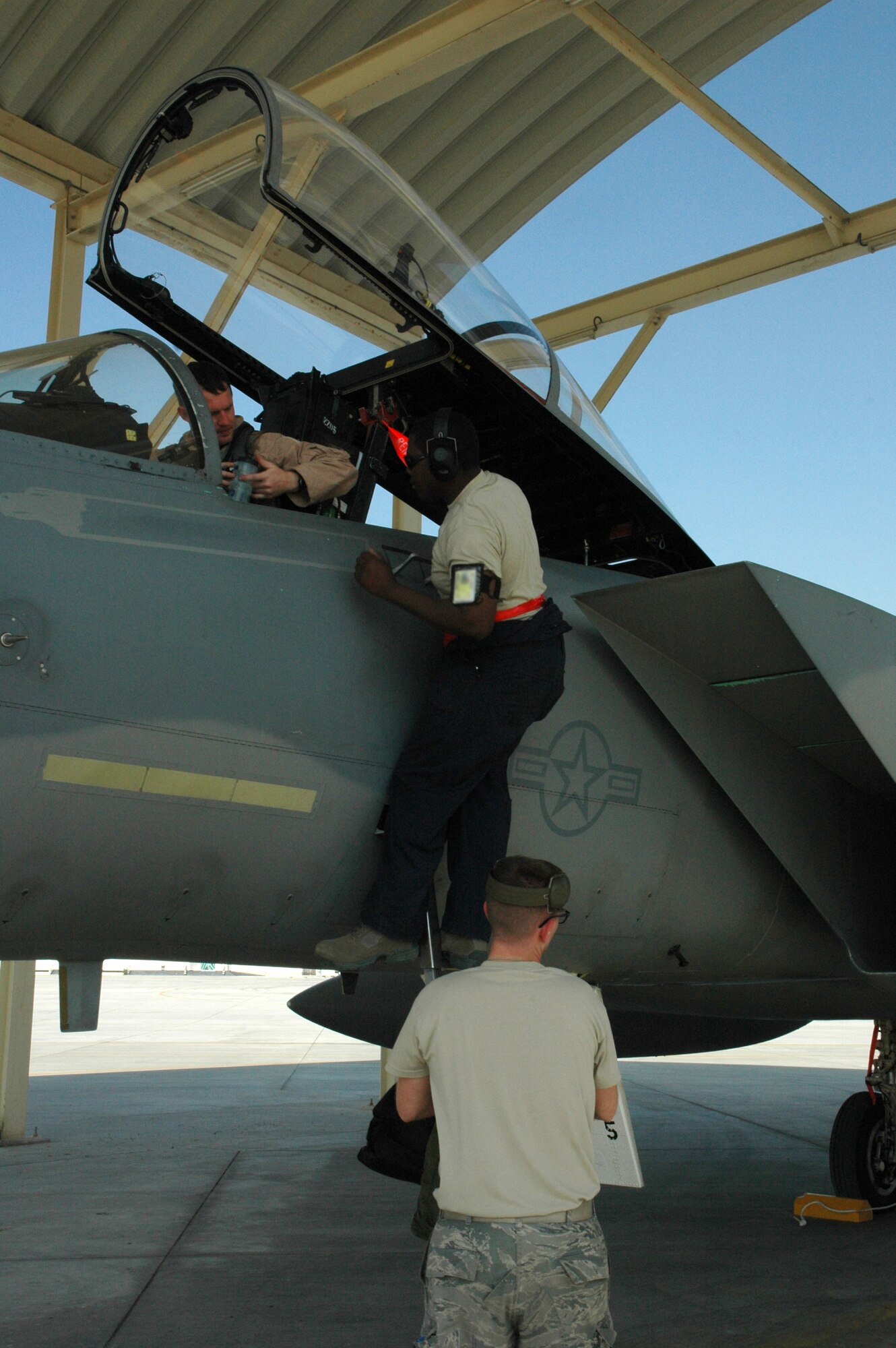 Maintainers from the 380th Expeditionary Aircraft Maintenance Squadron assist the 67th Expeditionary Fighter Squadron F-15C pilots after they arrived in Southwest Asia recently. The 67th EFS is deployed from Kadena AFB, Japan. (U.S. Air Force photo by Master Sgt. Julie Briden-Garcia)