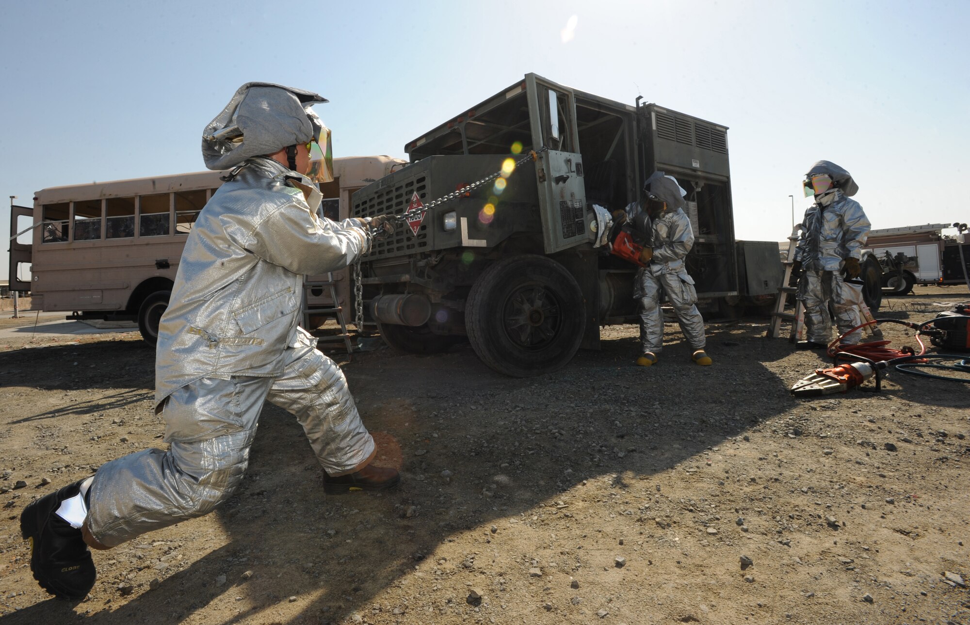 Firefighters from the 380th Expeditionary Civil Engineer Squadron remove a door from truck Jan. 28, 2011, during an Auto Extrication Exercise. These exercises keep the Airmen updated in their training which produce quick decision-making responses and save lives during real world scenarios. (U.S Air Force photo by Senior Airman Maynelinne De La Cruz)