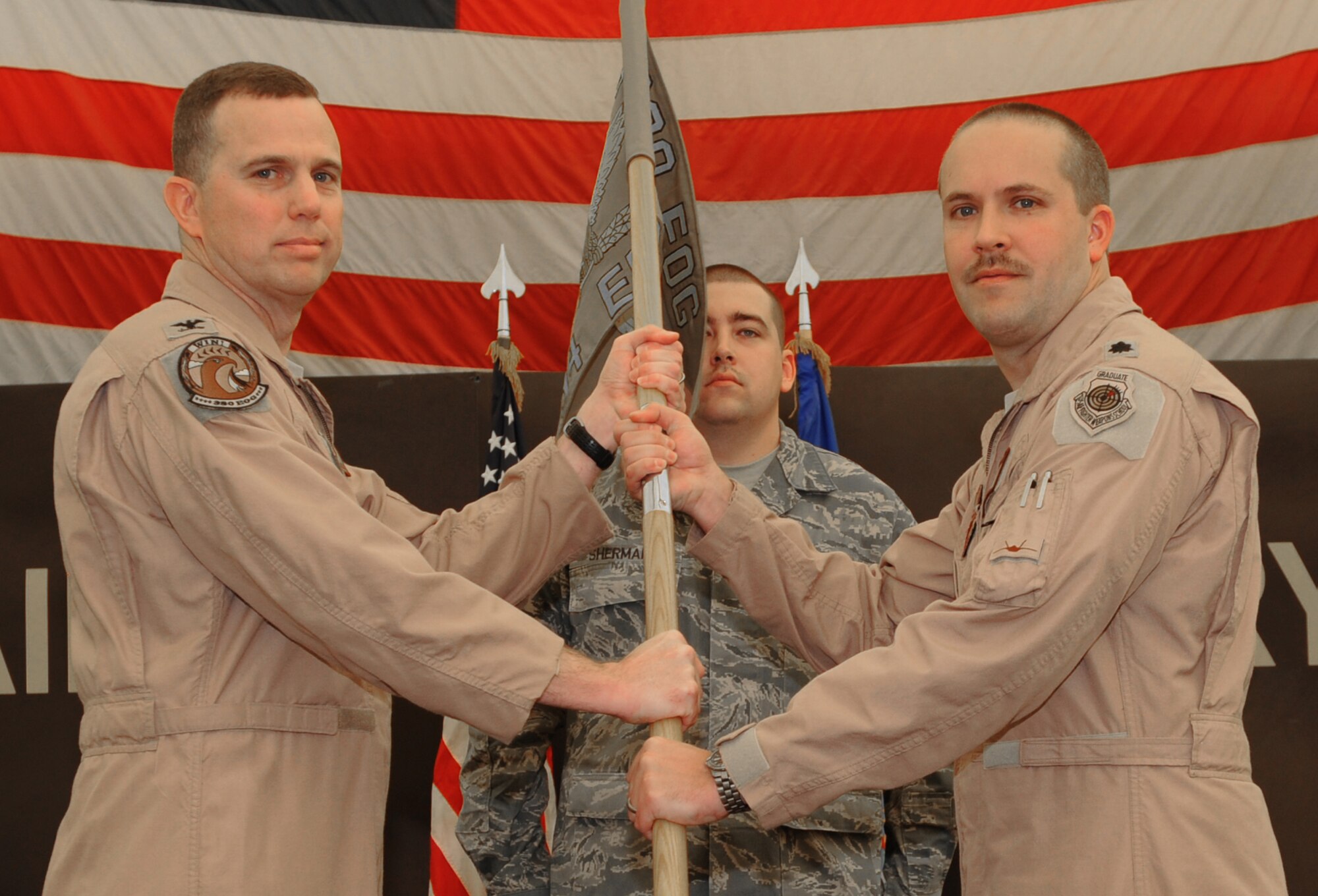 Col. Gregory Guillot, 380th Expeditionary Operations Group commander, presents Lt. Col. David Abba with the 94th Expeditionary Fighter Squadron guidon, activating the 94th EFS Jan. 28, 2011, in Southwest Asia. Colonel Abba recently arrived from Langley Air Force Base, Virginia. (U.S. Air Force photo by Senior Airman Maynelinne De La Cruz)