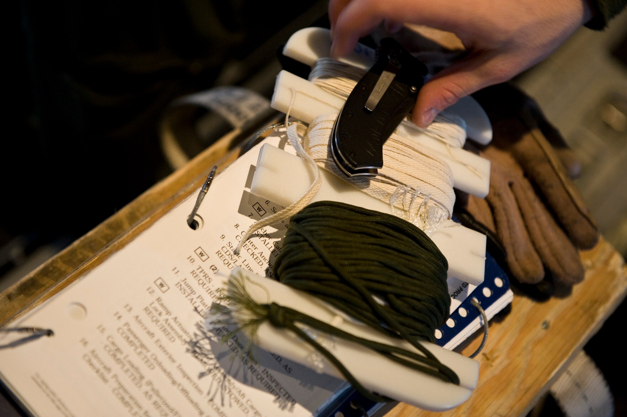U.S. Air Force Senior Airman Craig Morrison, 37th Airlift Squadron, reaches for a knife while preparing a C-130J Hercules, from Ramstein Air Base, Germany for an airdrop mission over the Marnheim, Germany drop zone, Feb. 10, 2011. The single C-130J aircraft from the 37th Airlift Squadron, 86th Airlift Wing dropped more than fifty service members at the drop site.  (U.S. Air Force photo/TSgt Wayne Clark, AFNE Regional News Bureau) (Released)