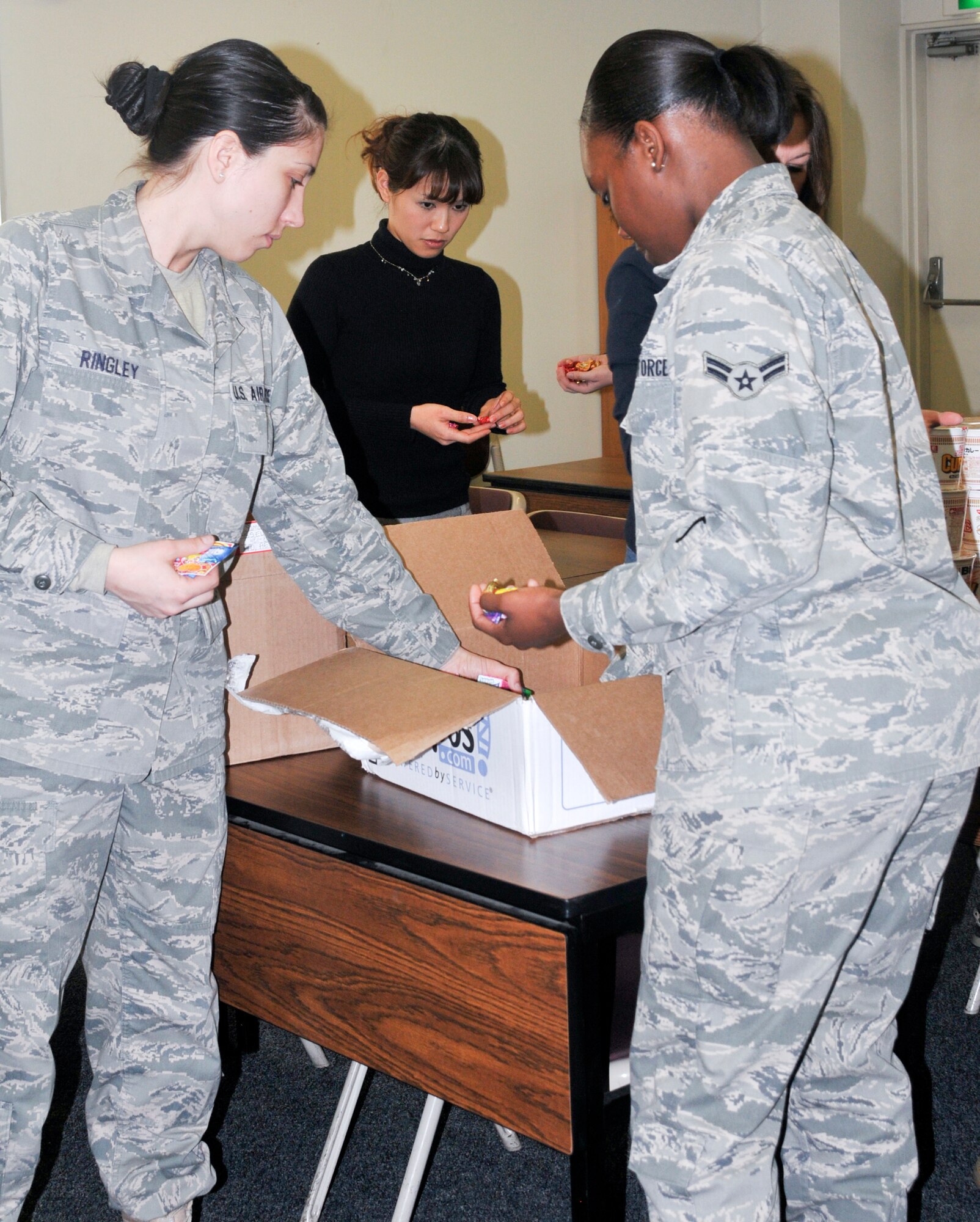 YOKOTA AIR BASE, Japan -- Airmen and Key Spouse committee members from the 374th Logistics Readiness Squadron create care packages for deployed squadron members here Feb. 9. (U.S. Air Force photo/Airman 1st Class Krystal M. Garrett) 