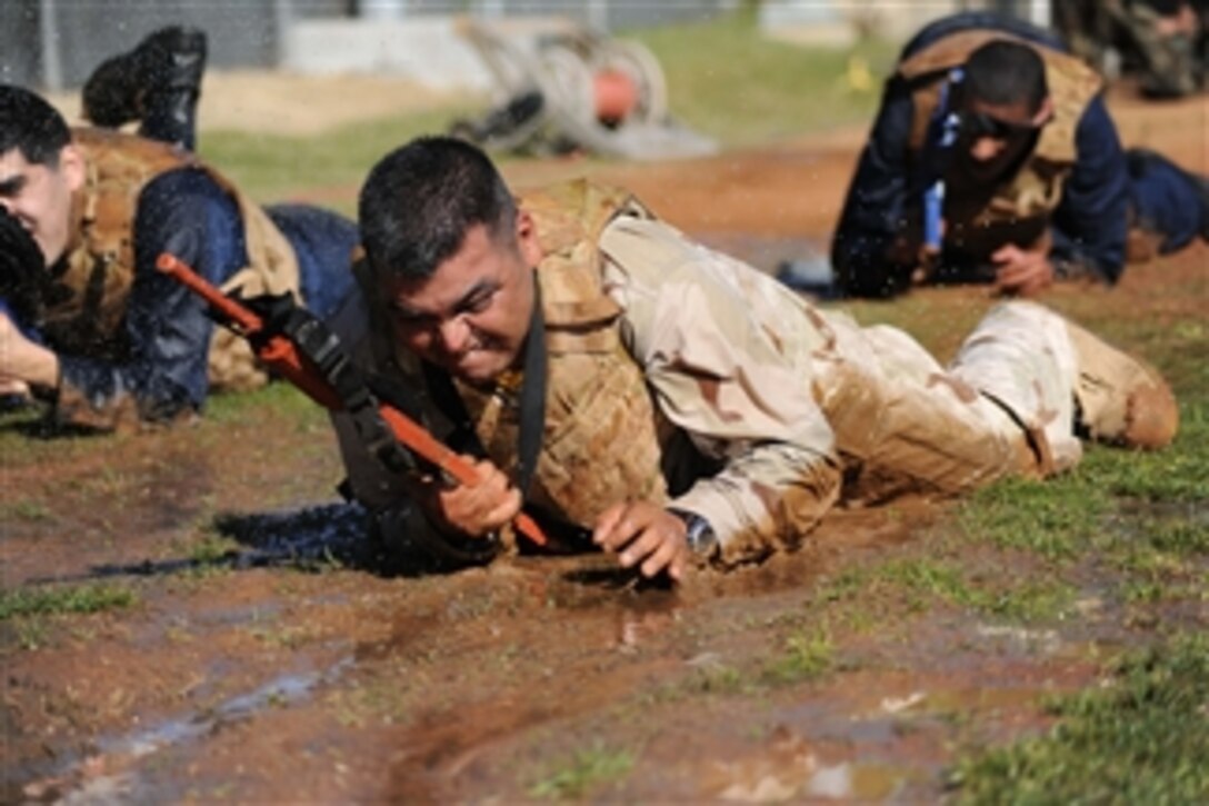 Petty Officer 1st Class Michael Astorga, a hospital corpsman, crawls through a mud pit during a tactical combat casualty care field exercise at Naval Medical Center San Diego on Feb. 3, 2011.  The exercise is a pre-deployment requirement.  Those who pass the course will be trained in managing the most common battlefield combat injuries.  