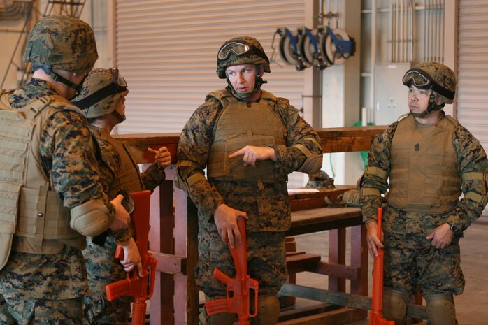 Gunnery Sgt. Shawn Lawson, Combat Logistics Company 36 maintenance chief, center, gives direction to Cpl. Andrea M. Olguin, a station combat photographer, near left, as Master Sgt. Joseph Pham, right, Combat Logistics Company 36 supply chief, looks on here Feb.16 as they prepare for their turn in the simulator as part of the Humvee Egress Awareness Training. They were tasked with evacuating an injured Marine. Olguin served as the injured.
