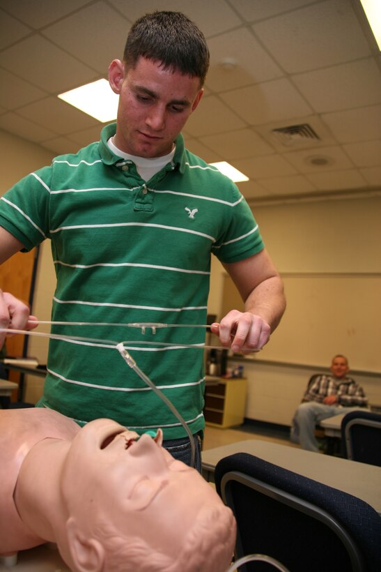 Lance Cpl. Michael T. Spisak prepares to put an oxygen tube on a breathing dummy during his test on rescue breathing and airways in a classroom at the Station Aircraft Rescue and Firefighting garage Feb. 16. The Marines are tested on various emergency situations to become certified as emergency medical technicians.