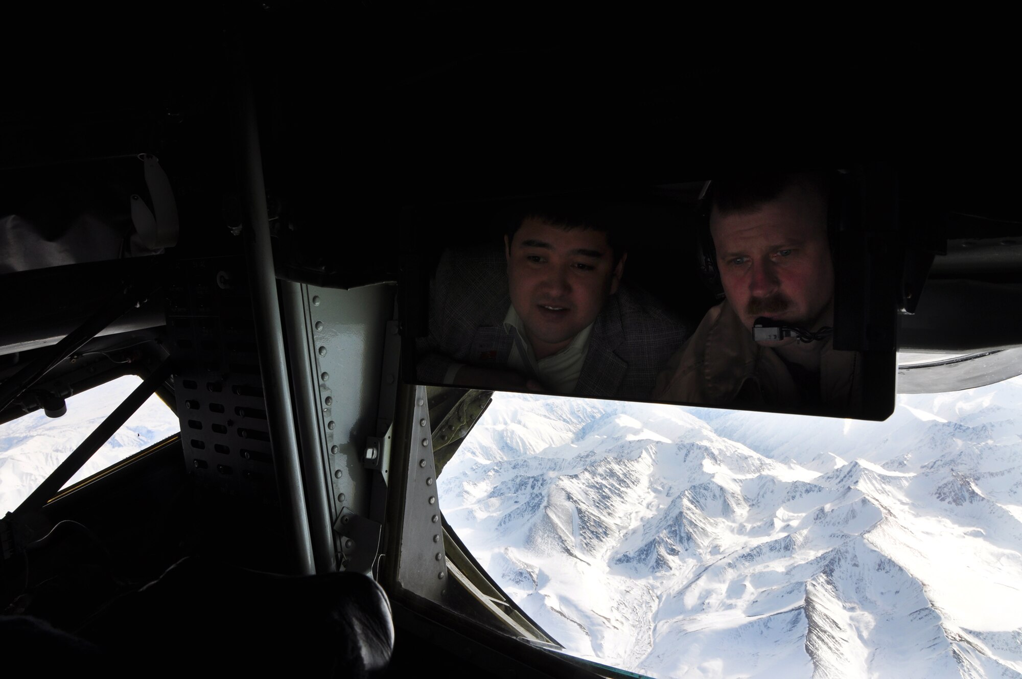 TRANSIT CENTER AT MANAS, Kyrgyzstan - Senior Master Sgt. Charles Jetton, 376th Expeditionary Operations Group, and a Kyrgyz parliamentarian enjoy the view from the boom operator position in a KC-135 Stratotanker on a first-ever flight for members of the parliment 16 Feb.  Parliament members were taken on the aircraft for a demonstration refueling mission with a C-17 Globemaster III over the skies of Kyrgyzstan. This demonstration of air power highlighted to the parliamentarians the role of the Aerial Refuel mission here, one of the Transit Center's four mission pillars. The other three pillars which were highlighted in the pre-flight briefing are Onward Movement, Airlift and Humanitarian Assistance. (U.S. Air Force photo/Master
Sgt. Daniel Nathaniel)
