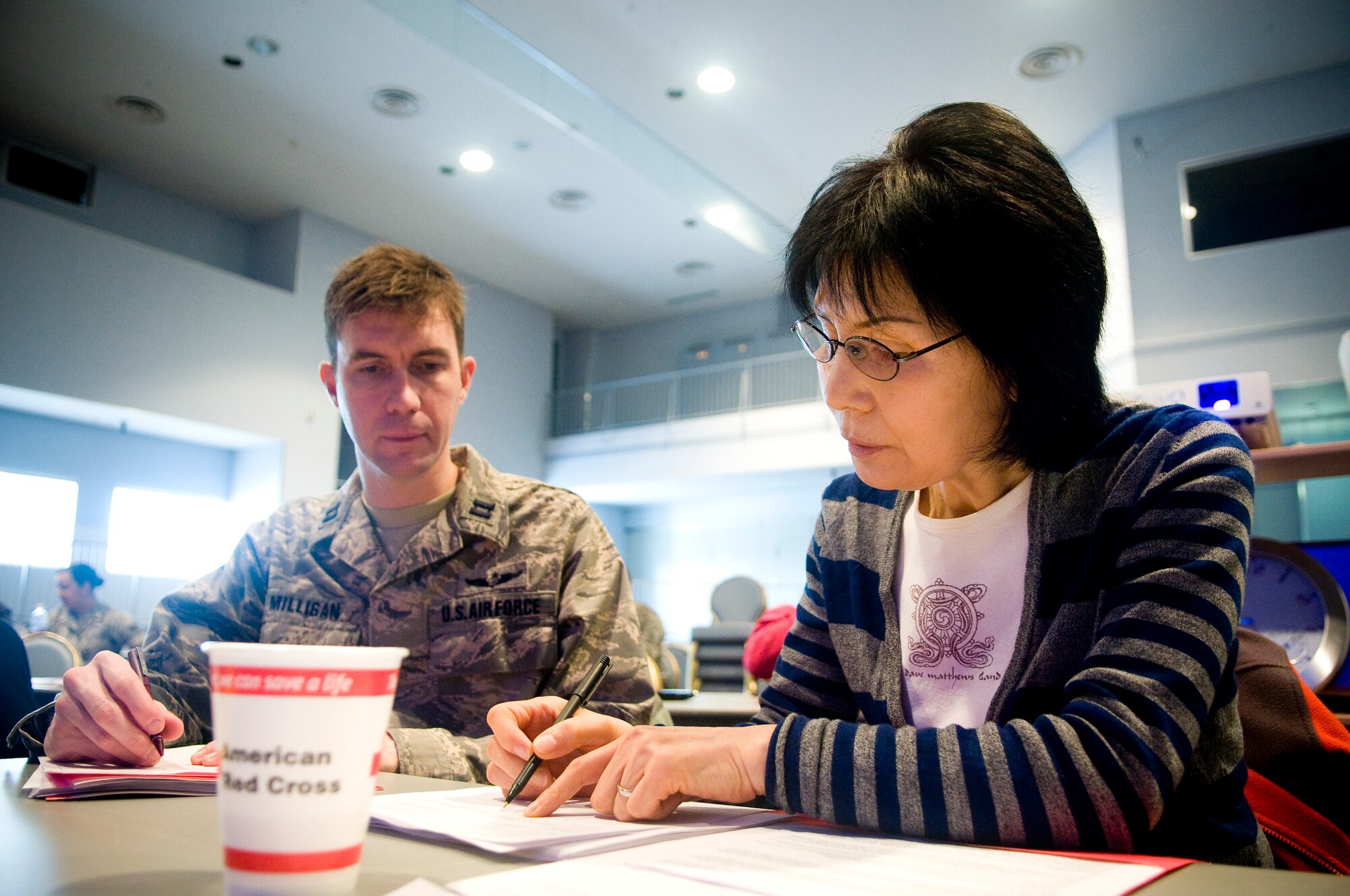 YOKOTA AIR BASE, Japan -- Hwa Brown (right), American Red Cross volunteer and Capt. Andrew Milligan, 374th Airlift Wing contingency planner, register each other during a simulated shelter operations exercise during annual American Red Cross training here Feb. 16. The training is conducted at the Taiyo Recreation Center and is open to all servicemembers and dependents who are 16 years old and older. (U.S. Air Force photo/Staff Sgt. Chad Strohmeyer)