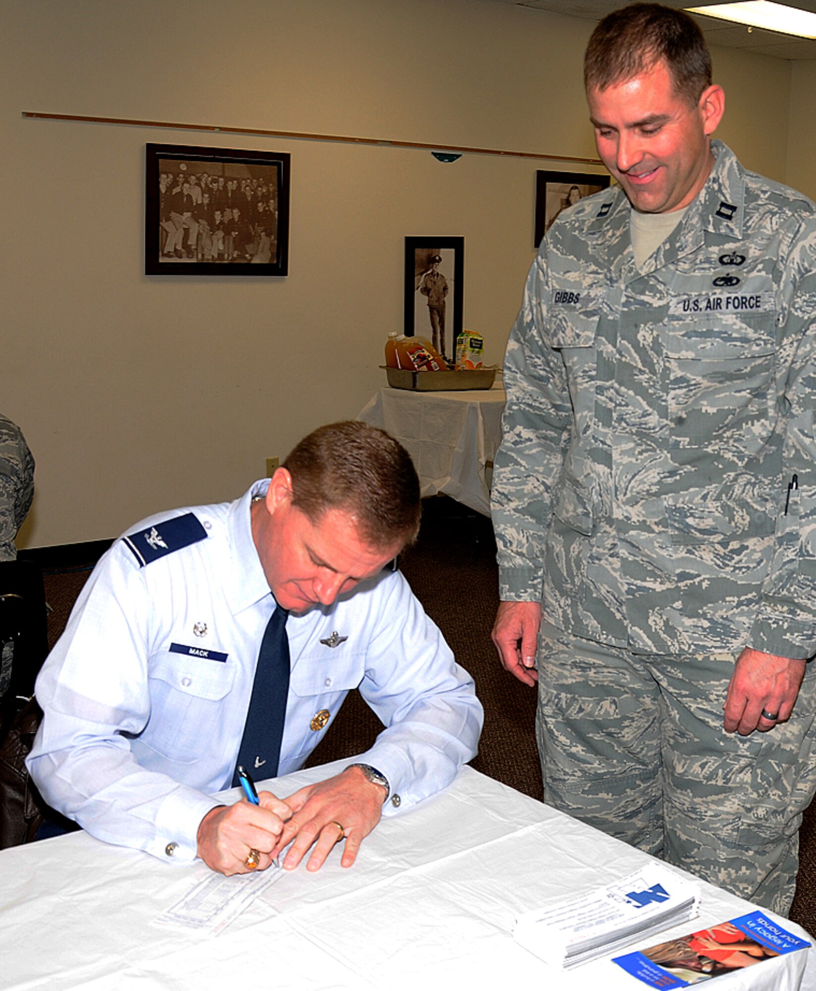 Col. Russ Mack, the 71st Flying Training Wing commander, fills out the first donation form of the 2011 Vance Air Force Assistance Fund campaign, while the campaign project officer, Capt. Todd Gibbs with the 71st Operations Support Squadron, looks on. (U.S. Air Force photo/ Angie Roche)