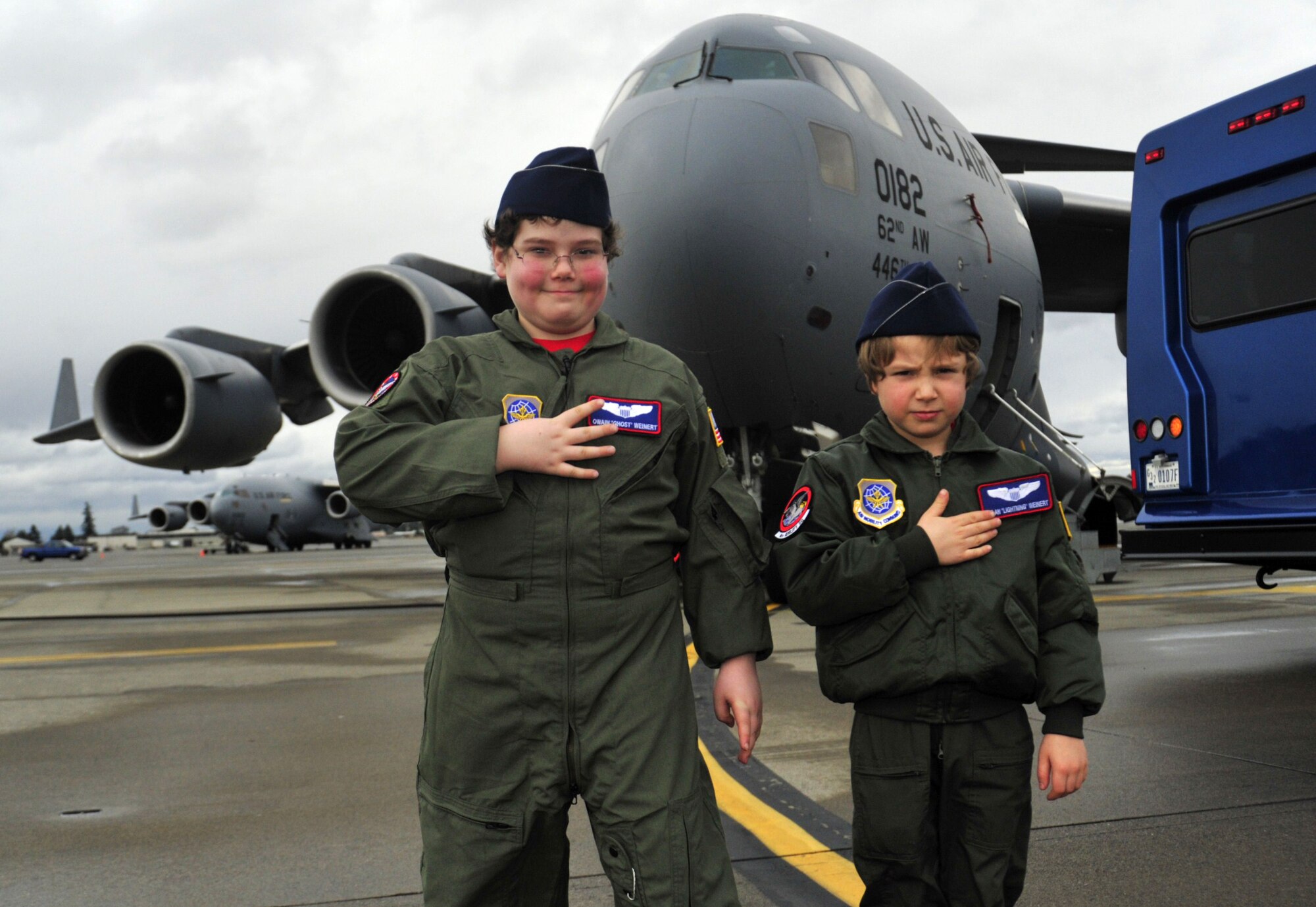 Owain Weinert, left, 9, and brother Dylan, 7, stand in front of a C-17 Globemaster III as part of the Pilot for a Day program Feb. 15 at Joint Base Lewis-McChord, Wash. While touring the C-17, they sat in the pilot’s seat and learned about the engines. (U.S. Air Force photo/Airman 1st Class Leah Young)