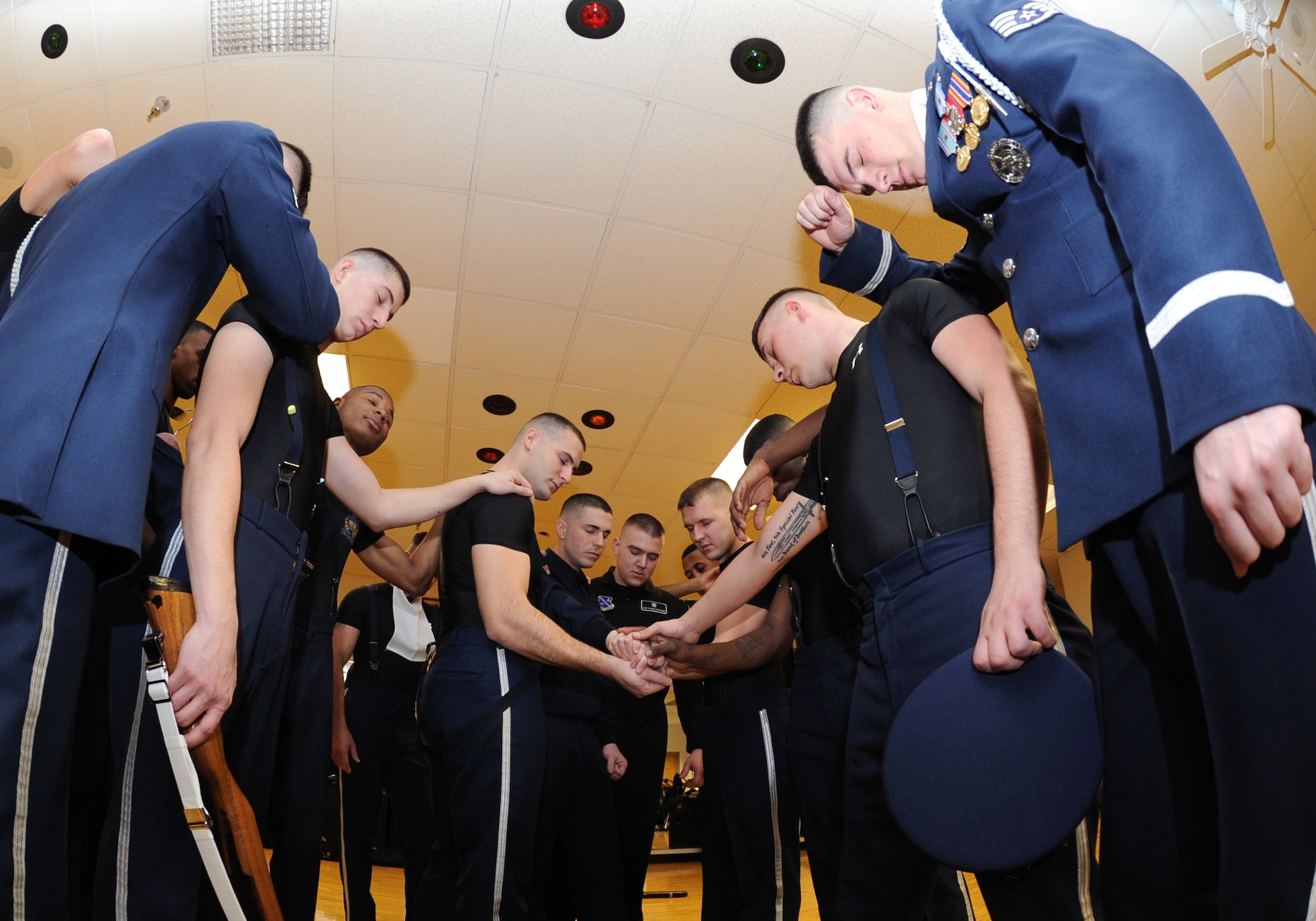 Members of the U.S. Air Force Honor Guard Drill Team huddle for a team prayer following a performance Feb. 14, 2011, McConnell Air Force Base, Kan. The prayer helps mentally and spiritually prepare the team before and after drill performances. The U.S. Air Force Honor Guard has been representing past and present members of the U.S. Air Force for over 60 years. (U.S. Air Force photo/Senior Airman Maria A. Ruiz)