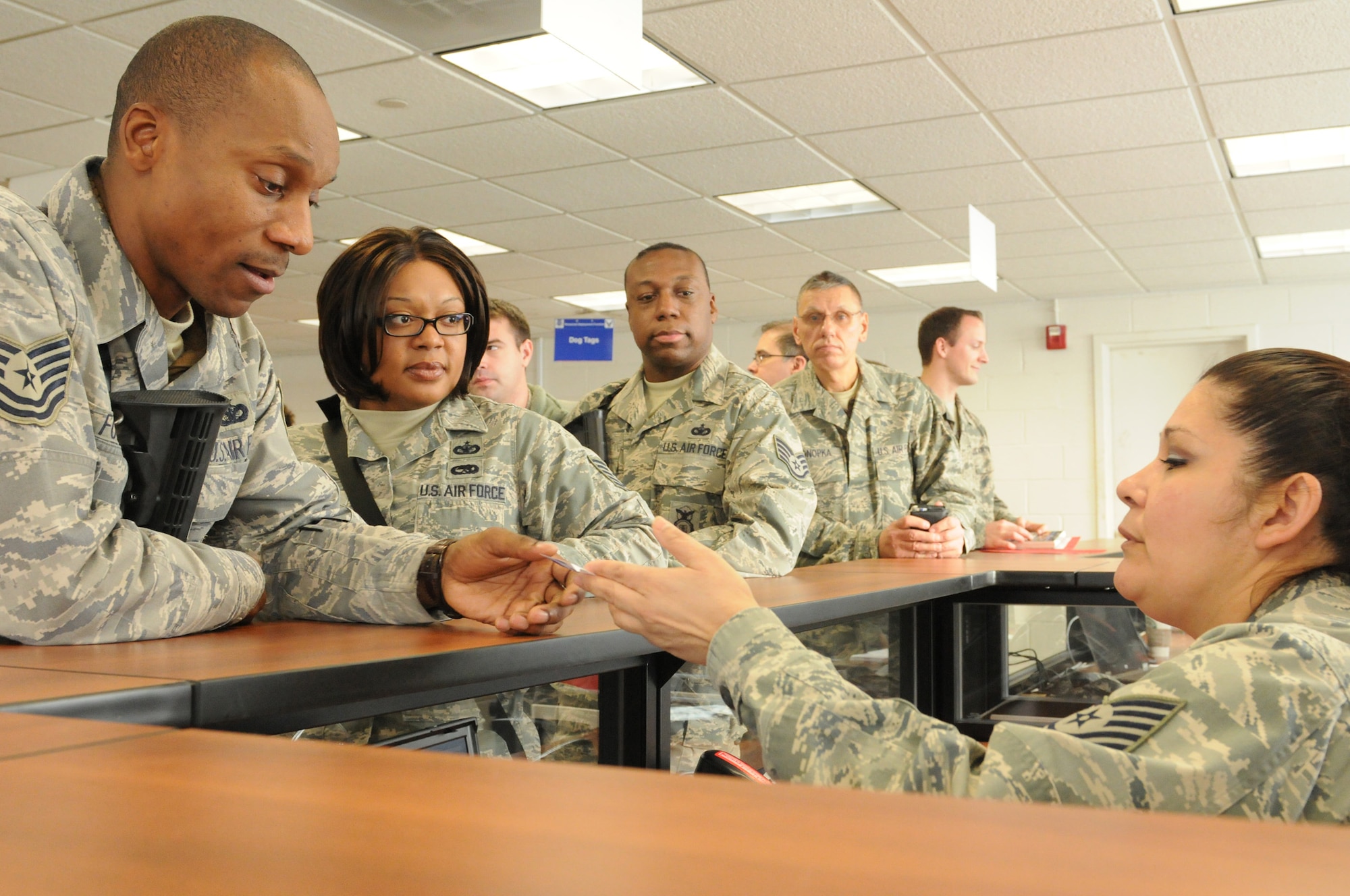JOINT BASE ANDREWS, Md. -- An 11th Wing legal specialist checks military identification cards and provides information to 459th Air Refueling Wing deployers during a mobility exercise Feb. 4 here. Along with processing through a Deployment Control Center, 459 ARW Reserve Airmen also faced scenarios like preparing cargo for airlift, donning Chemical Protective Overgarments and searching for Unexploded Ordinance during exercise Vantage Rally/Tiger Claw 11-01. The 459 ARW worked alongside the active duty 11 WG and the 89 WG during the exercise in order to prepare for an upcoming Operational Readiness Inspection. (U.S. Air Force photo/Tech. Sgt. Steve Lewis)
