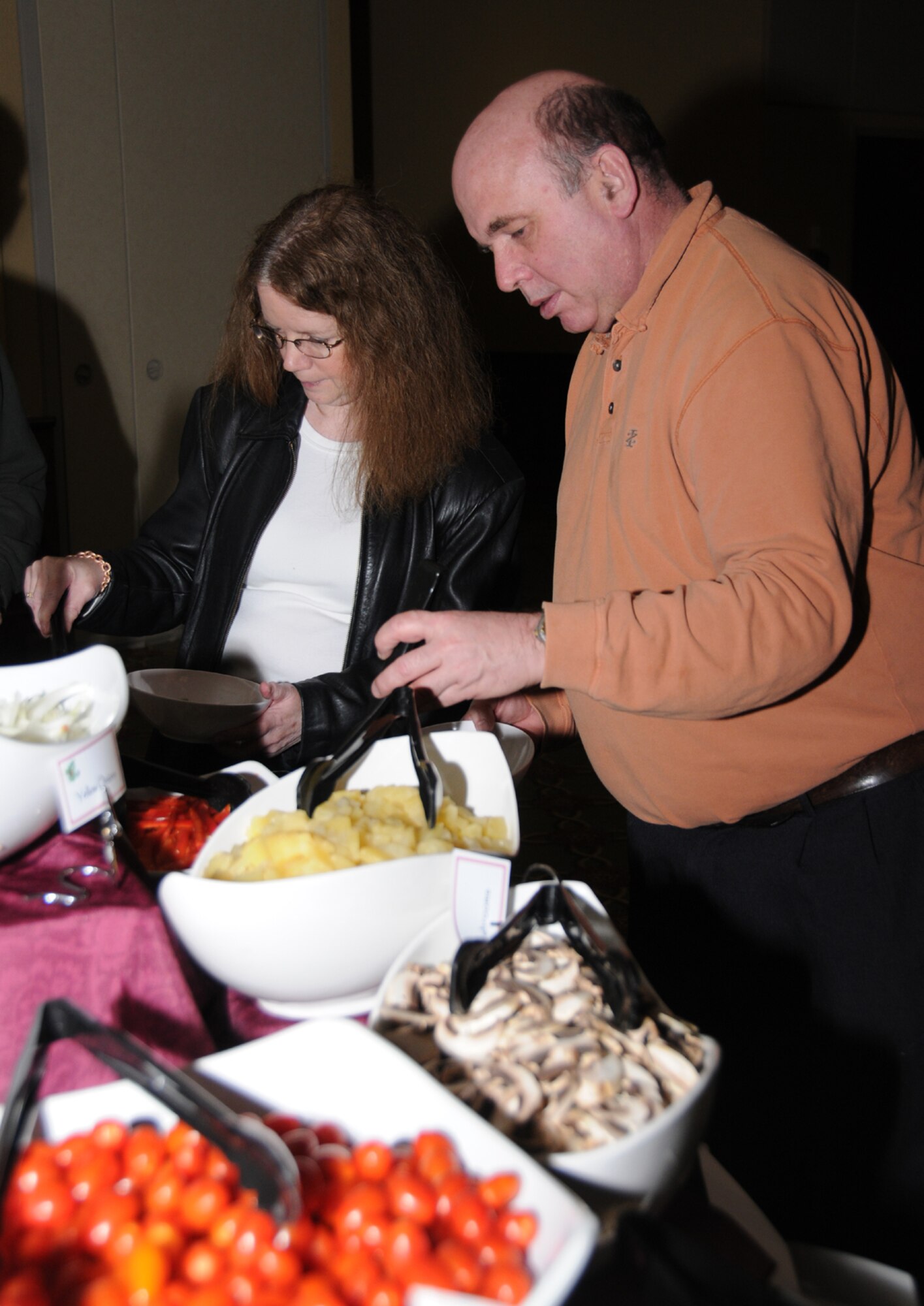 Dixie and Wayne Huber from Biloxi prepare their Mongolian barbecue dishes for the kitchen staff to prepare, Feb. 10. Mr. Huber is a retired master sergeant.  Three different meats and a variety of vegetables are  offered to diners to combine to satisfy their own particular tastes for 95 cents per ounce for club members and $1.10 for nonmembers.  (U.S. Air Force photo by Kemberly Groue)