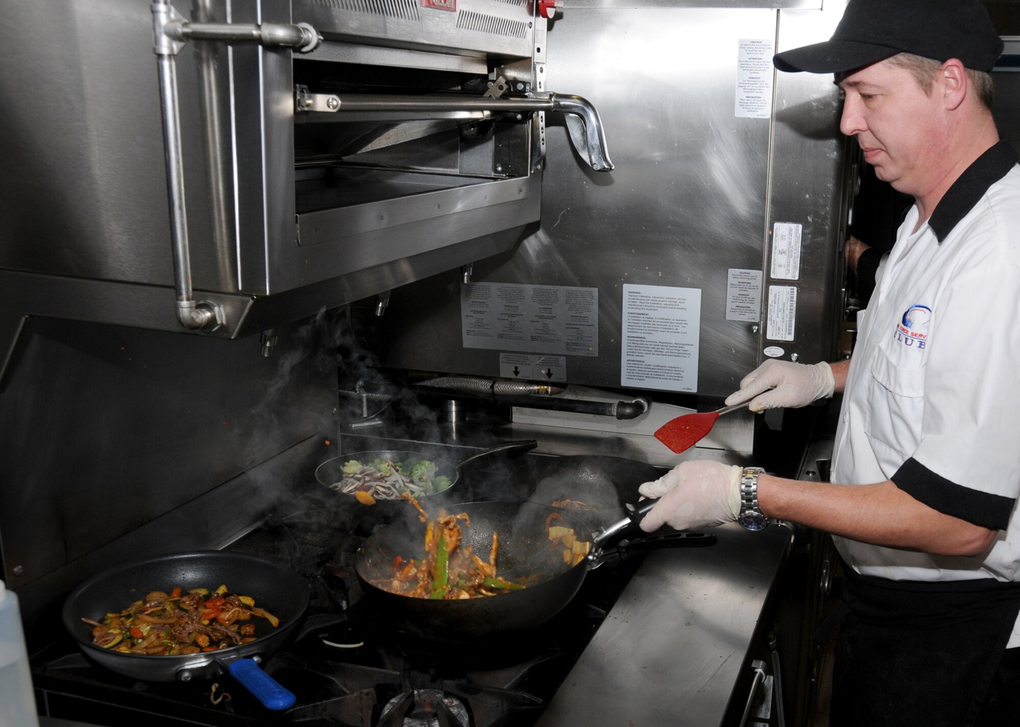 Mark Cowan, lead cook at the Bay Breeze Event Center, cooks Mongolian
barbecue meals, Feb. 10. Mongolian barbecues are featured twice a month
— the next one is 5-8 p.m.Wednesday in the Bay Breeze ballroom.  (U.S. Air Force photo by Kemberly Groue)