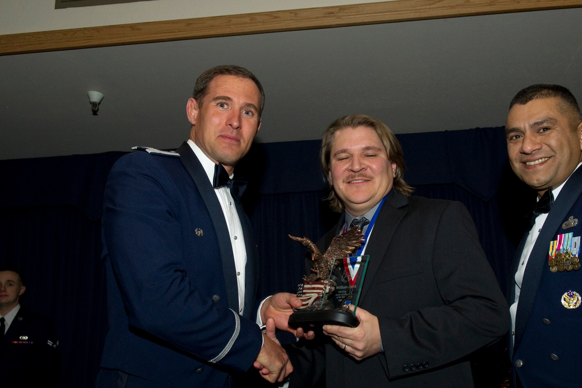 HOLLOMAN AIR FORCE BASE, N.M. -- William Urick, 49th Operations Group, receives the Senior Civilian of the Year award from Col. David Krumm, 49th Wing commander, during the Wing’s Annual Awards Ceremony, Feb. 11. Mr. Urick managed Holloman’s busiest ranges by clearing 120 tons of unexploded ordinances. Additionally, he oversaw the installation of a $50,000 remote weather station that provides realistic and safe combat training for thousands of joint and coalition forces. The nominees for Senior Civilian of the Year were Mr. Urick; Augustus Neverson, 49th Materiel Maintenance Group; Maurice Lopez, 49th Medical Group; Thomas Mitchell, 49th Mission Support Group; and Gerald Laver, 49th Wing Staff. (U.S. Air Force photo by Airman 1st Class Eileen Payne and Airman 1st Class Joshua Turner/Released)
