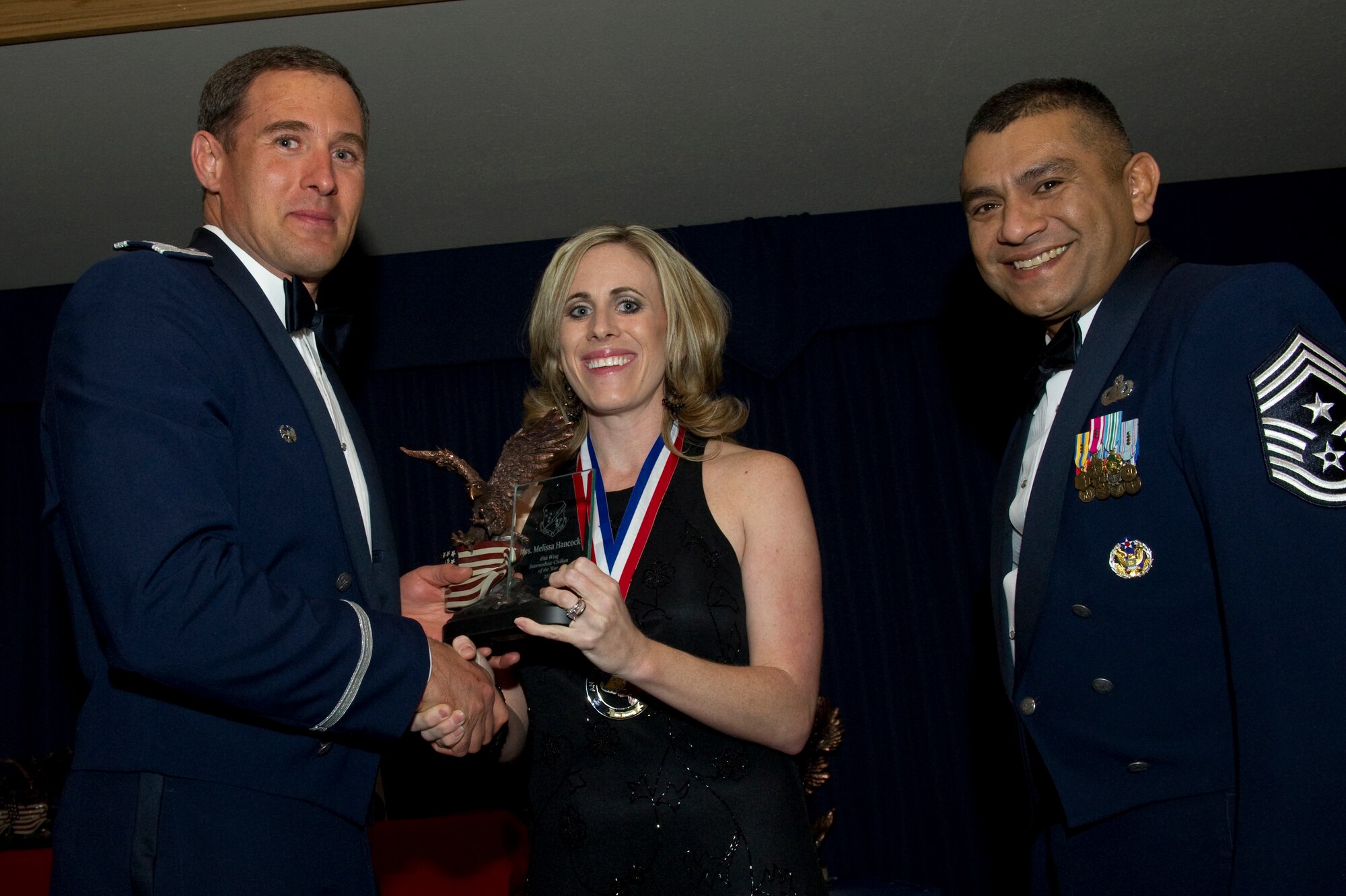 HOLLOMAN AIR FORCE BASE, N.M. -- Melissa Hancock, 49th Wing Staff, receives the Intermediate Civilian of the Year award from Col. David Krumm, 49th Wing commander, during the Wing’s Annual Awards Ceremony, Feb. 11. Ms. Hancock led five congressional visits, coordinated 17 change of commands and 173 visits of distinguished members, while completing the first unit of Squadron Officer School and several credits toward her master’s degree. These actions led to her selection as the 2010 first and third quarter wing staff Intermediate Civilian of the Quarter. The nominees for Intermediate Civilian of the Year were Ms. Hancock; Francisco Perez Delgado, 49th Materiel Maintenance Group; Diane Morrill, 49th Medical Group; Kimberly Lawhorn, 49th Mission Support Group; and Juan Laverreda Perez, 49th Operations Group. (U.S. Air Force photo by Airman 1st Class Eileen Payne and Airman 1st Class Joshua Turner/Released)