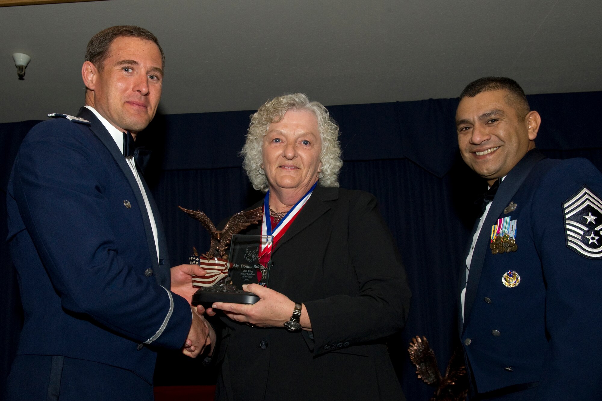 HOLLOMAN AIR FORCE BASE, N.M. -- Donna Boots, 49th Medical Group, receives the Junior Civilian of the Year award from Col. David Krumm, 49th Wing commander, during the Wing’s Annual Awards Ceremony, Feb. 11. Ms. Boots piloted the Daughters of the American Revolution Patriot Project, collecting comfort items valued at $1,500. Additionally, through astute management and review of more than 46 records and 100 custodians, she took the medical group’s file plan from worst to first in one year. The nominees for Junior Civilian of the Year were Ms. Boots; Dolores Soto, 49th Maintenance Group; Catherine Levin, 49th Mission Support Group; and Candance Kerr, 49th Operations Group. (U.S. Air Force photo by Airman 1st Class Eileen Payne and Airman 1st Class Joshua Turner/Released)