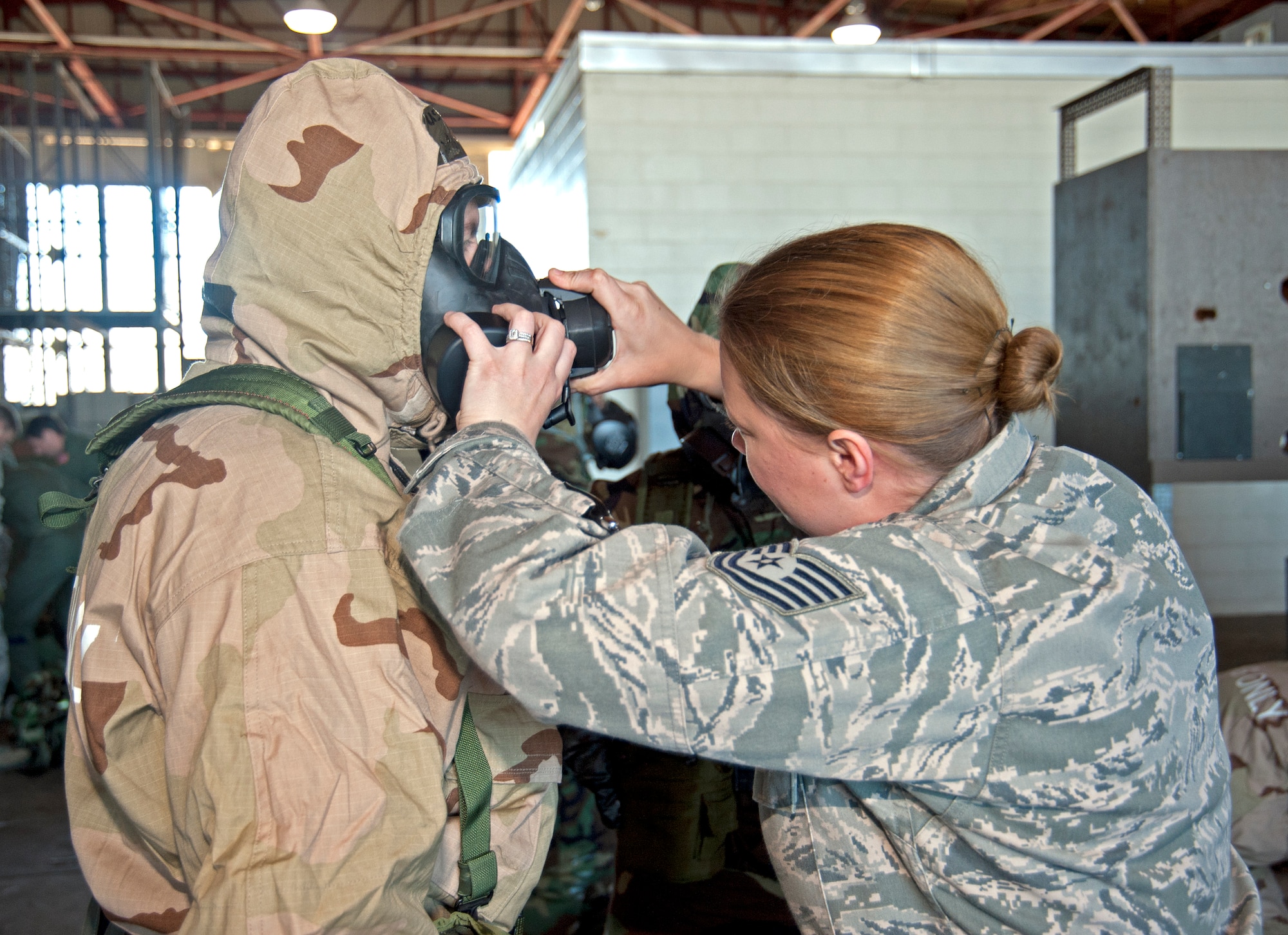 Sergeant Jennifer Simmons assists with the M50 mask filter placement for Senior Master Sgt. Brian Harms, 403rd Wing command post Feb. 13, during the Unit Training Assembly.  Reservists from the 403rd Wing continue to train for the January 2012 Operational Readiness Inspection. (U.S. Air Force photo by Dhiana McKaig)