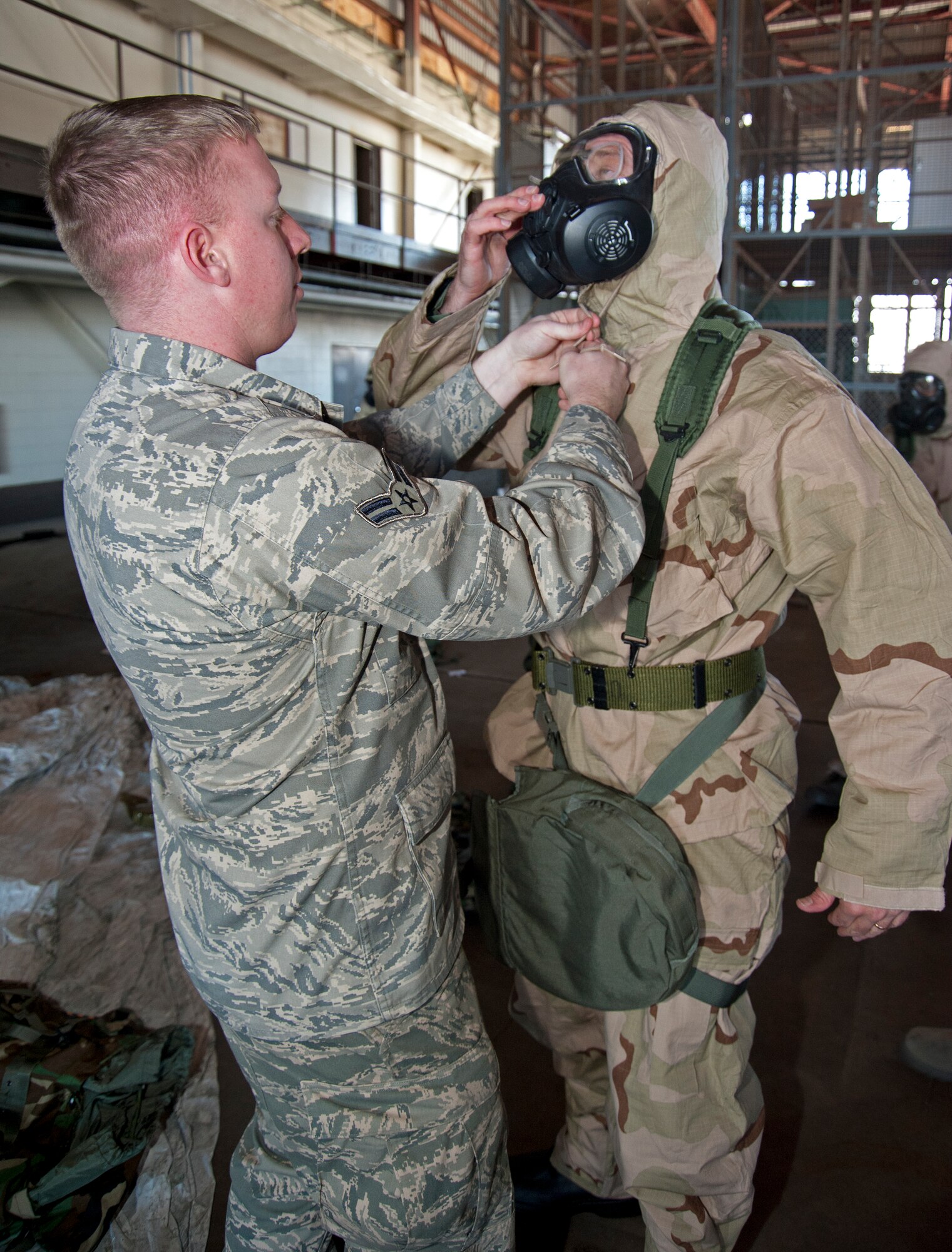 Airman 1st Class Christopher Wright, 302nd Civil Engineer Squadron emergency management instructor, Peterson AFB, Colo., securely fastens the hood for Tech. Sgt. Mark Scott, 403rd Wing finance office, to ensure his M50 mask fits properly Feb. 13, during the Unit Training Assembly.  Reservists from the 403rd Wing continue to train for the January 2012 Operational Readiness Inspection. (U.S. Air Force photo by Dhiana McKaig)