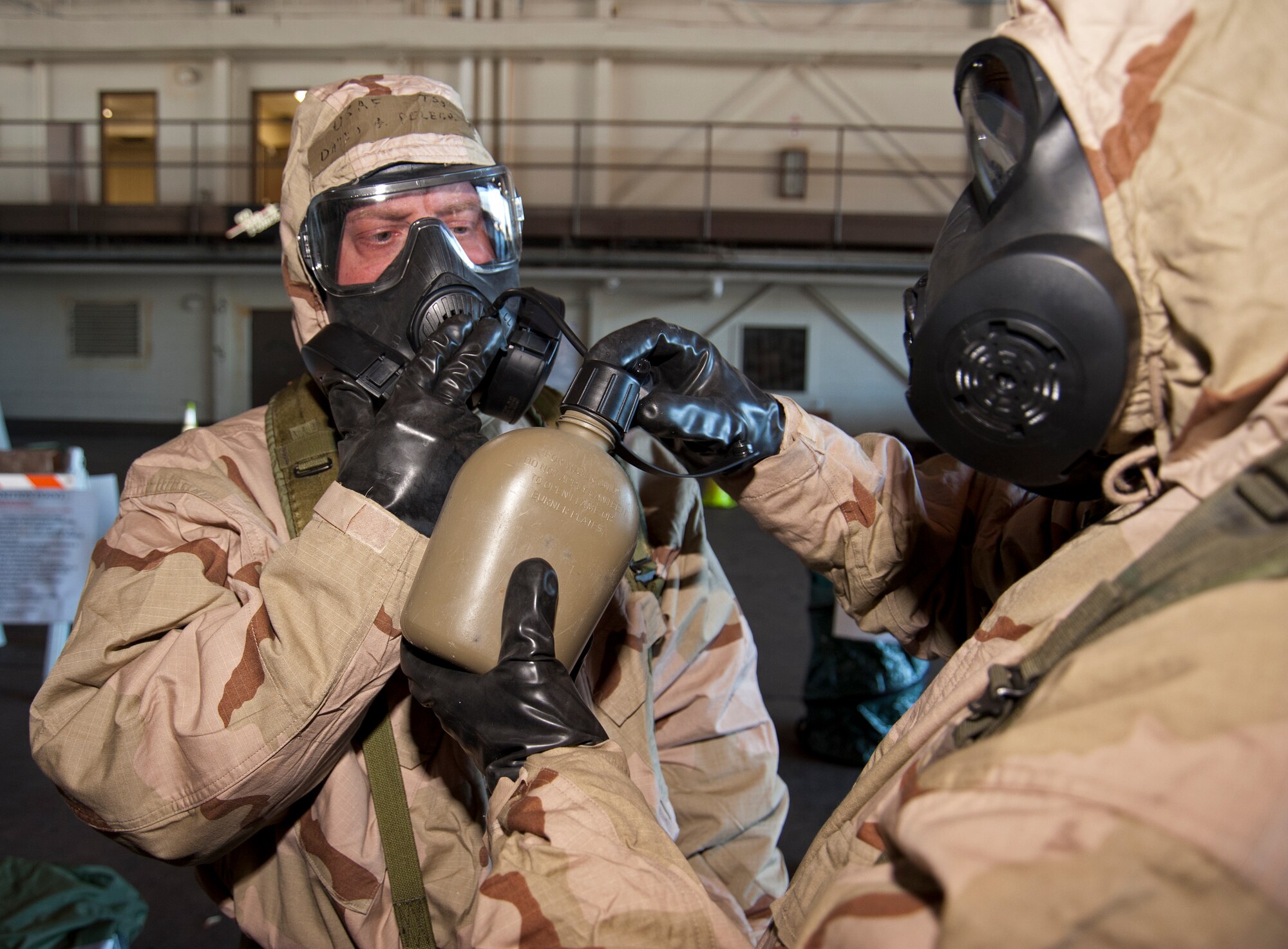Sergeants Wieckowski and Delegrin learn how to properly connect a water canteen to the M50 mask Feb. 13, during the Unit Training Assembly.  Reservists from the 403rd Wing continue to train for the January 2012 Operational Readiness Inspection. (U.S. Air Force photo by Dhiana McKaig)