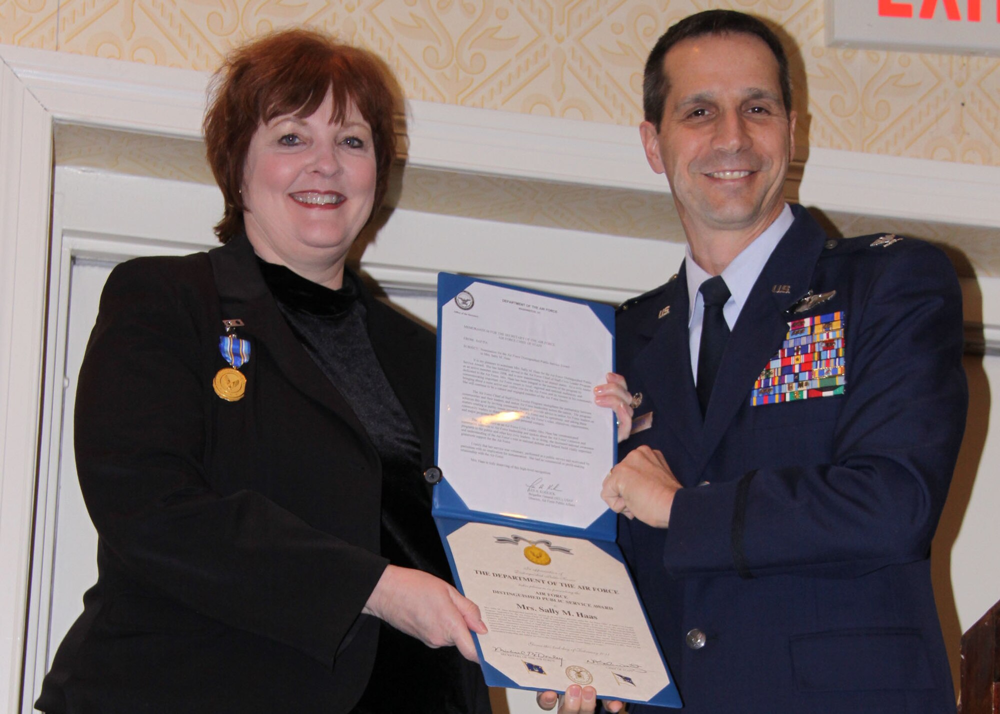 Mrs. Sally Haas, Pittsburgh Airport Area Chamber of Commerce president, is honored by Col. Jeffrey T. Pennington, 911th Airlift Wing commander, during a breakfast briefing Feb. 11, for an award she recently received from the Secretary of the Air Force.   Secretary of the Air Force, Michael B. Donley, presented Mrs. Haas with the Air Force Distinguished Public Service Award during a ceremony Feb. 4 at Joint Base Anacostia-Bolling in Washington, D.C.  It is the highest honorary civilian award the Secretary of the Air Force may grant to a private citizen.  Mrs. Haas earned the award for her advocacy of Air Force issues and for her dedicated support of Airmen and their families while serving as a member of the Air Force Chief of Staff Civic Leader Program.(U.S. Air Force photo/By Senior Master Sgt. Mark Winklosky)