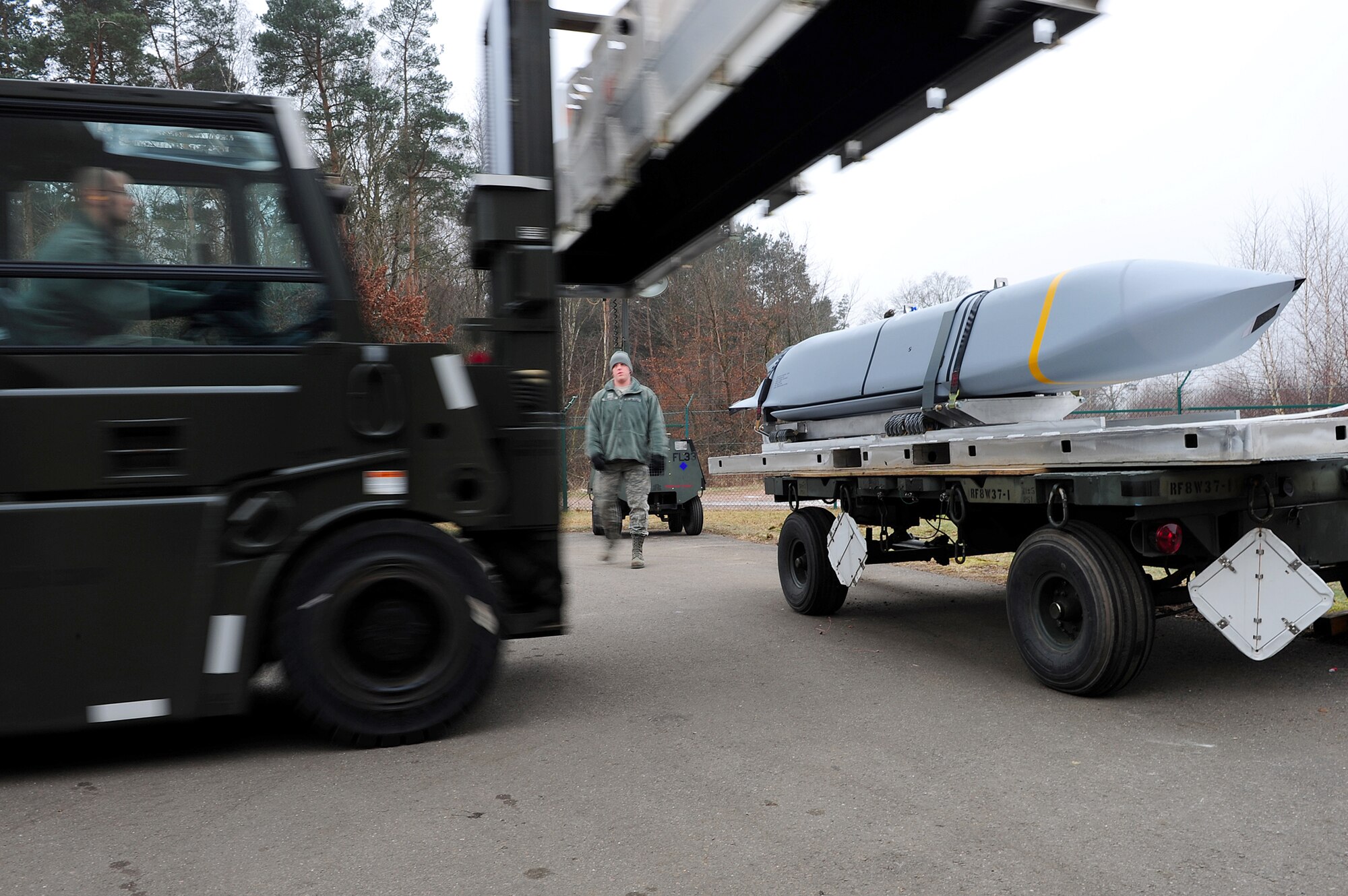 Airmen from the 86th Munitions Squadron get in position to secure a joint air-to-surface standoff missile Feb. 1, 2011, at Ramstein Air Base, Germany. The 2,000-pound, semi-stealth, long-range weapon requires various maintenance and test operations to ensure its efficiency. (U.S. Air Force photo/Airman 1st Class Brea Miller)