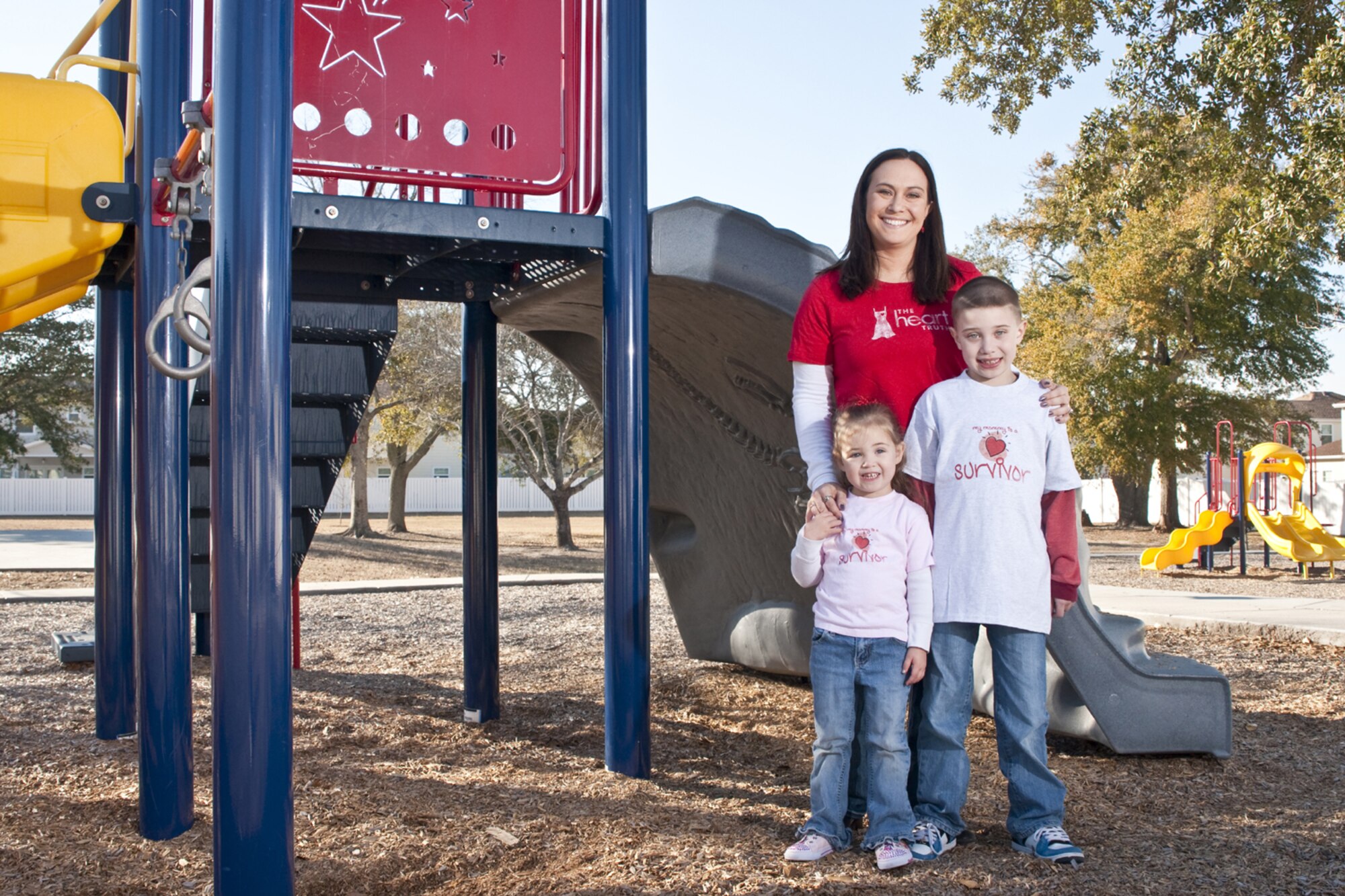 Heart survivor Trisha Meagher and her two children, Felicity, 3, and Luke, 7, play at a Keesler playground. Sergeant Meagher, 333rd TRS, is currently deployed to Afghanistan.  (Photo by John Stricklin)