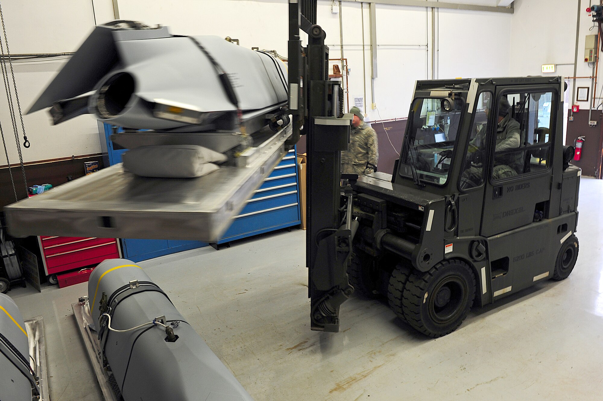 Airmen from the 86th Munitions Squadron get in position to secure a joint air-to-surface standoff missile Feb. 1, 2011, at Ramstein Air Base, Germany. The 2,000-pound, semi-stealth, long-range weapon requires various maintenance and test operations to ensure its efficiency. (U.S. Air Force photo/Airman 1st Class Brea Miller)