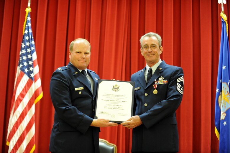 Col. Cam LeBlanc, Director of the 4th Air Force Logistics Division, congratulates Chief Master Sgt. Thomas Tschida, 4th Air Force Logistics Division, during Chief Tschida's Feb. 12, 2011 retirement ceremony at the March Air Reserve Base’s Cultural Resources Center. Chief Tschida retired after 33 years of military service. (U.S. Air Force photo/Staff Sgt. Matthew Smith)