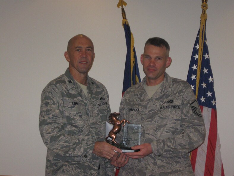 Col. Timothy Lamb, commander 567th RED HORSE, presents the 567th RED HORSE Senior Non-Commissioned Officer of the Year award to Master Sgt. Daniel Connolly. (USAF photo by SrA Jasmine Ealey, 567 RHS)