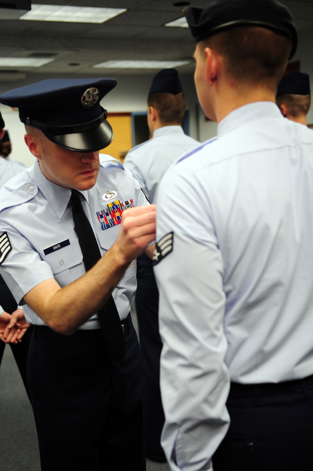 Staff Sgt. Matthew Chute, 375th Force Support Squadron’s Airman Leadership School instructor, measures the distance between a student’s functional badge and ribbons during ALS class 11-B blues inspection Jan. 31, 2011 at Scott Air Force Base, Ill. Airmen attending ALS are new or future staff sergeants and spend 24 academic days learning the tools and skills to become effective NCOs and supervisors upon completion of the course. Additionally, they will be evaluated on drill performance, and complete three uniform inspections. (U.S. Air Force photo/Staff Sgt. Teresa M. Jennings)