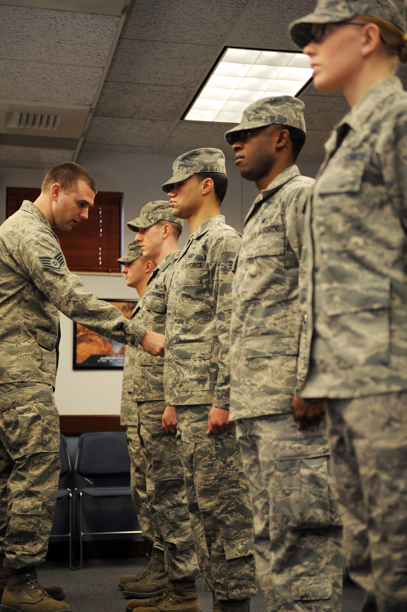Staff Sgt. Casey Jensen, 375th Force Support Squadron’s Airman Leadership School instructor, points out a uniform discrepancy to a student of ALS class 11-B during their ABU inspection Jan. 13, 2011 at Scott Air Force Base, Ill.  During the 24 academic days Airmen spend at ALS they will have three uniform inspections, six tests and six writing assignments. (U.S. Air Force photo/Staff Sgt. Teresa M. Jennings)