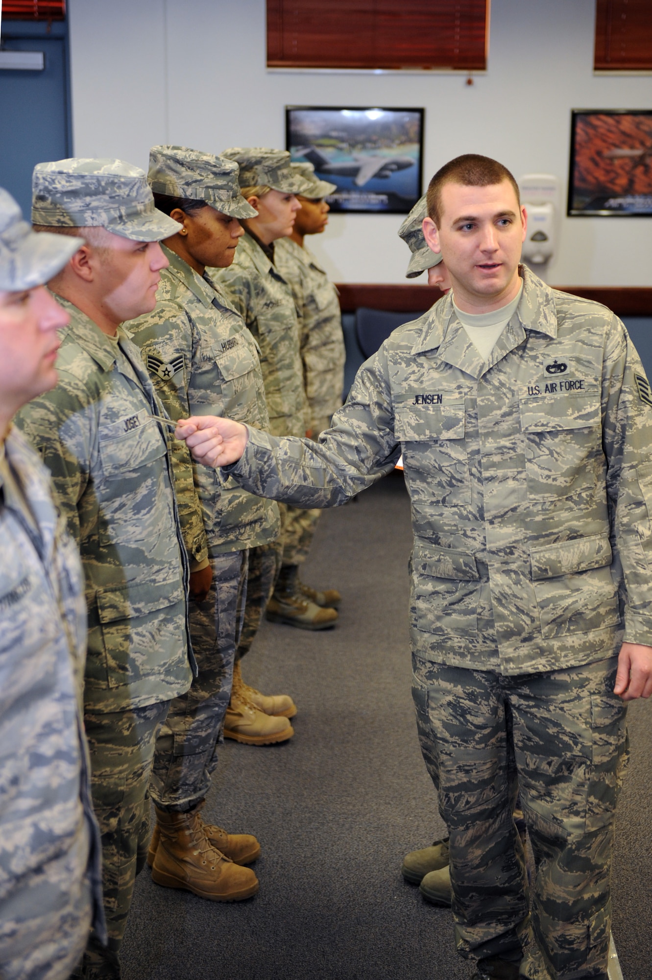 During an ABU inspection for ALS class 11-B, Staff Sgt. Casey Jensen, 375th Force Support Squadron’s Airman Leadership School instructor, verifies a possible uniform discrepancy with fellow instructors Jan. 13, 2011 at Scot Air Force Base, Ill during ALS class 11-B’s ABU inspection. During the 24 academic days Airmen spend at ALS they will have three uniform inspections, six tests and six writing assignments. (U.S. Air Force photo/Staff Sgt. Teresa M. Jennings)